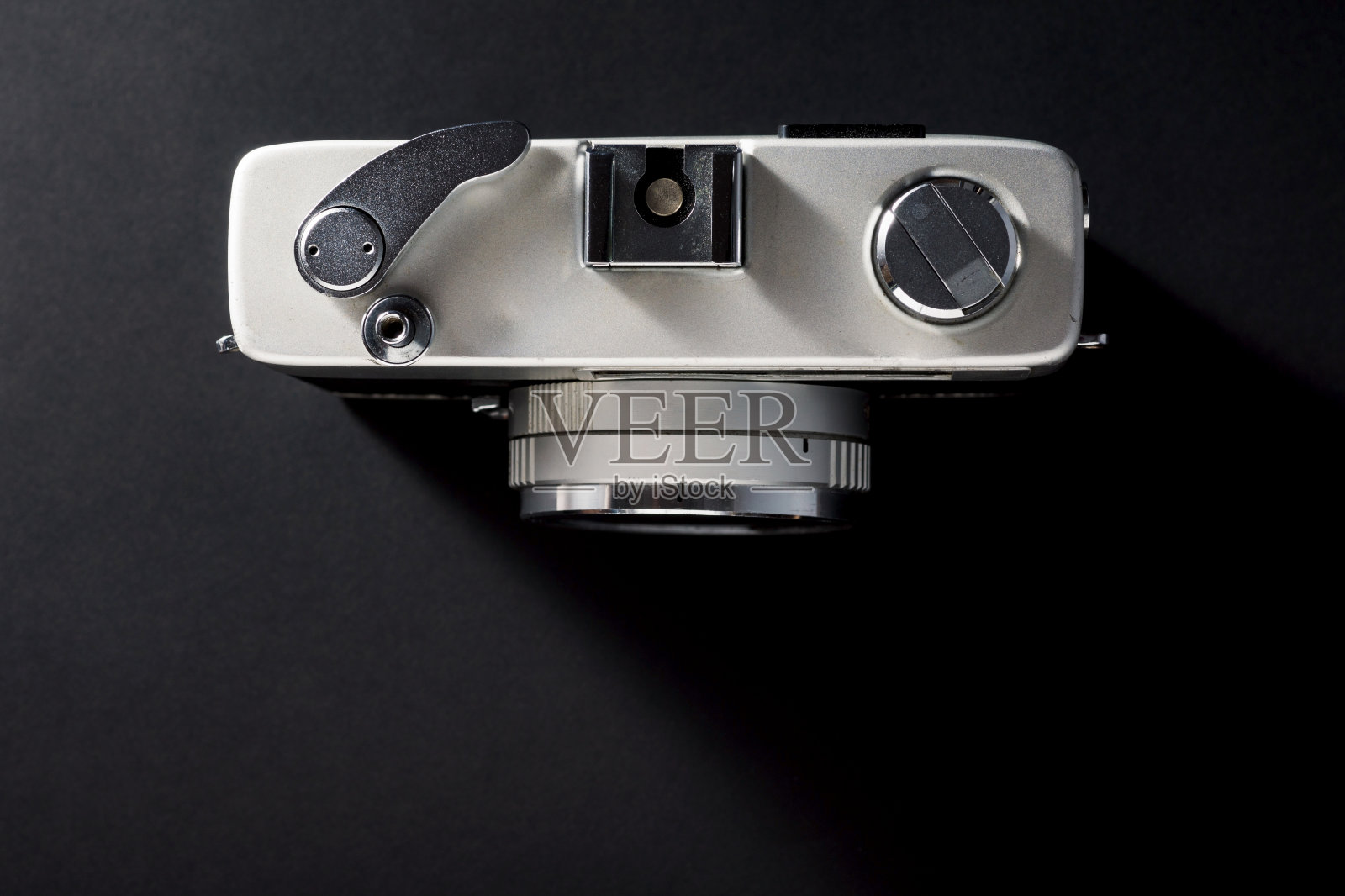 顶部视图的旧和过时的老式紧凑型胶片相机在黑暗的背景与阴影照片摄影图片