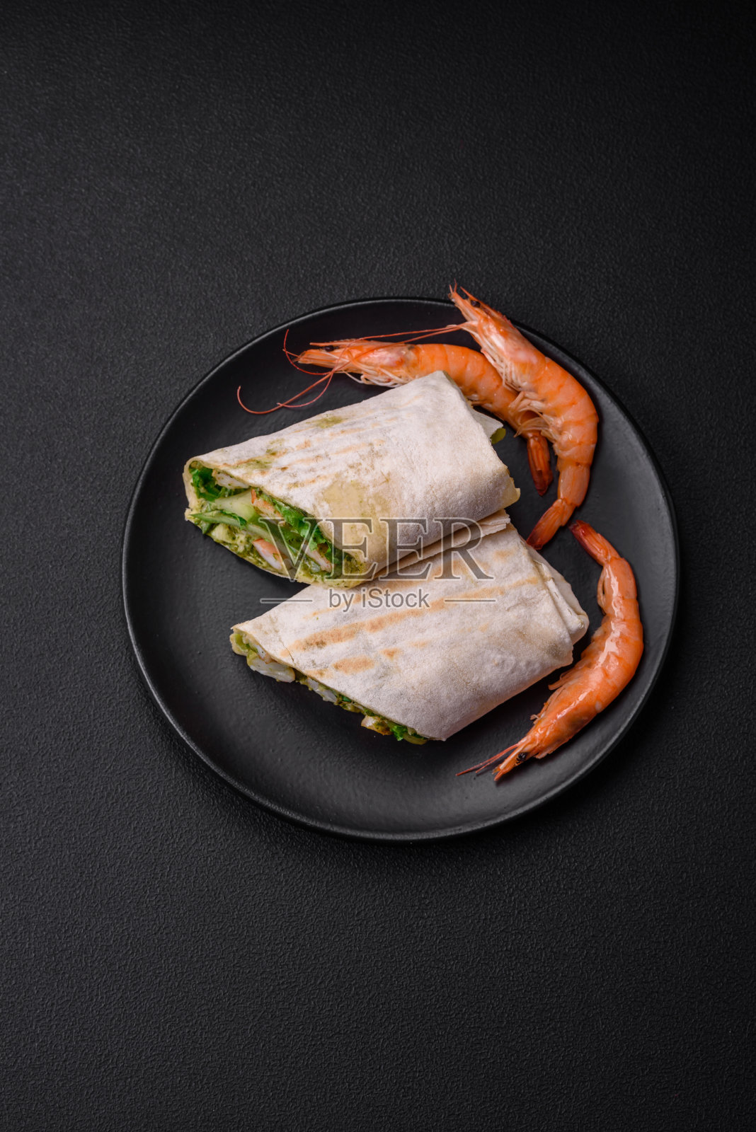 新鲜美味的皮塔饼卷，配以虾、番茄、生菜和黄瓜照片摄影图片