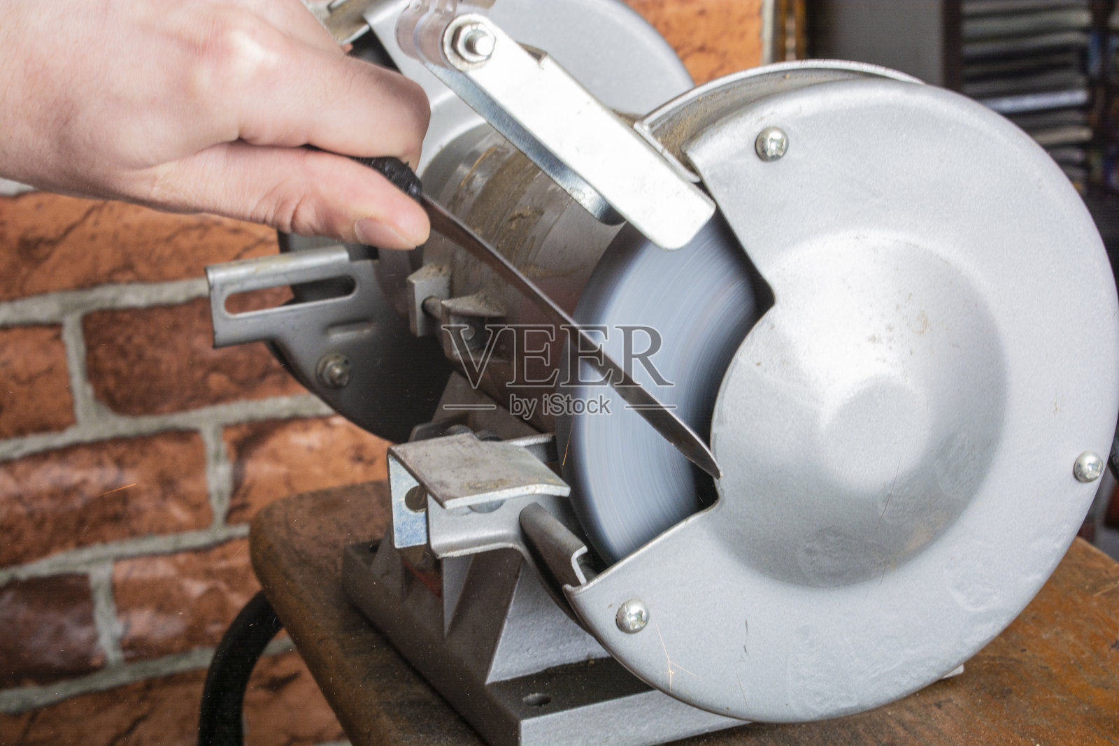 木桌上的磨刀手和刀片，特写照片摄影图片