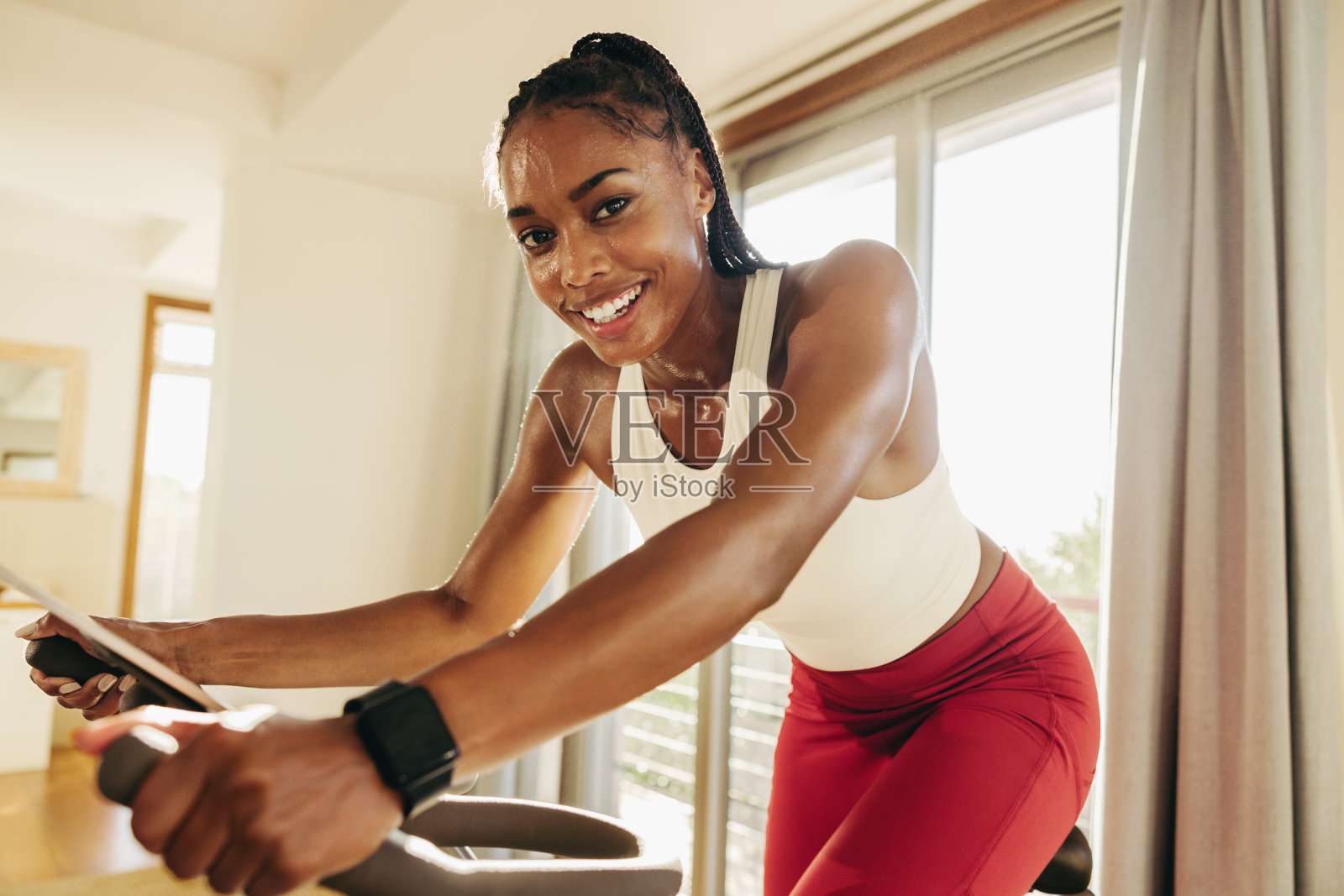 快乐的年轻女子用家用自行车设备粉碎了她的健身目标照片摄影图片
