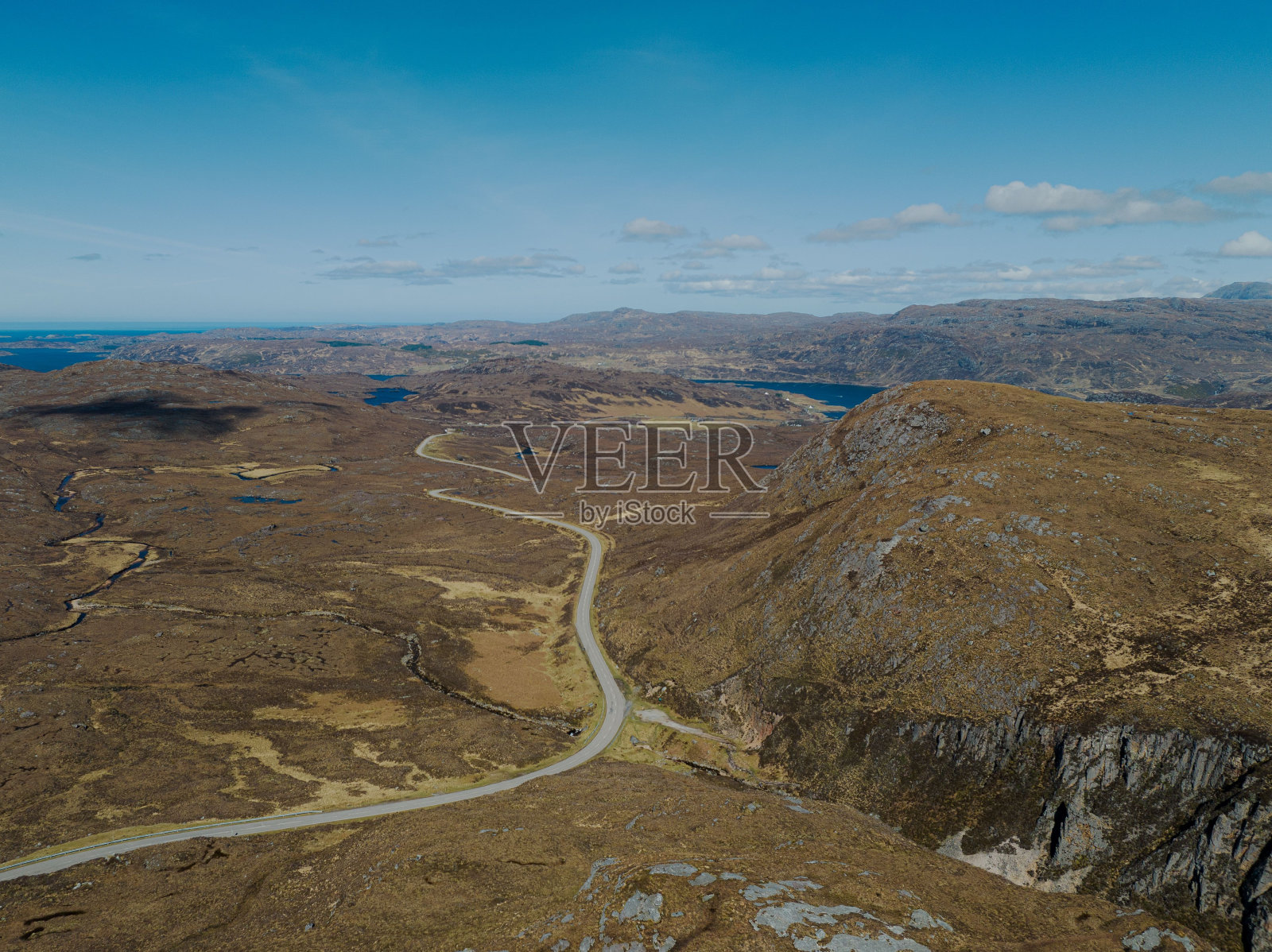 这条路穿过群山，通向一个湖泊和一个遥远的山谷照片摄影图片