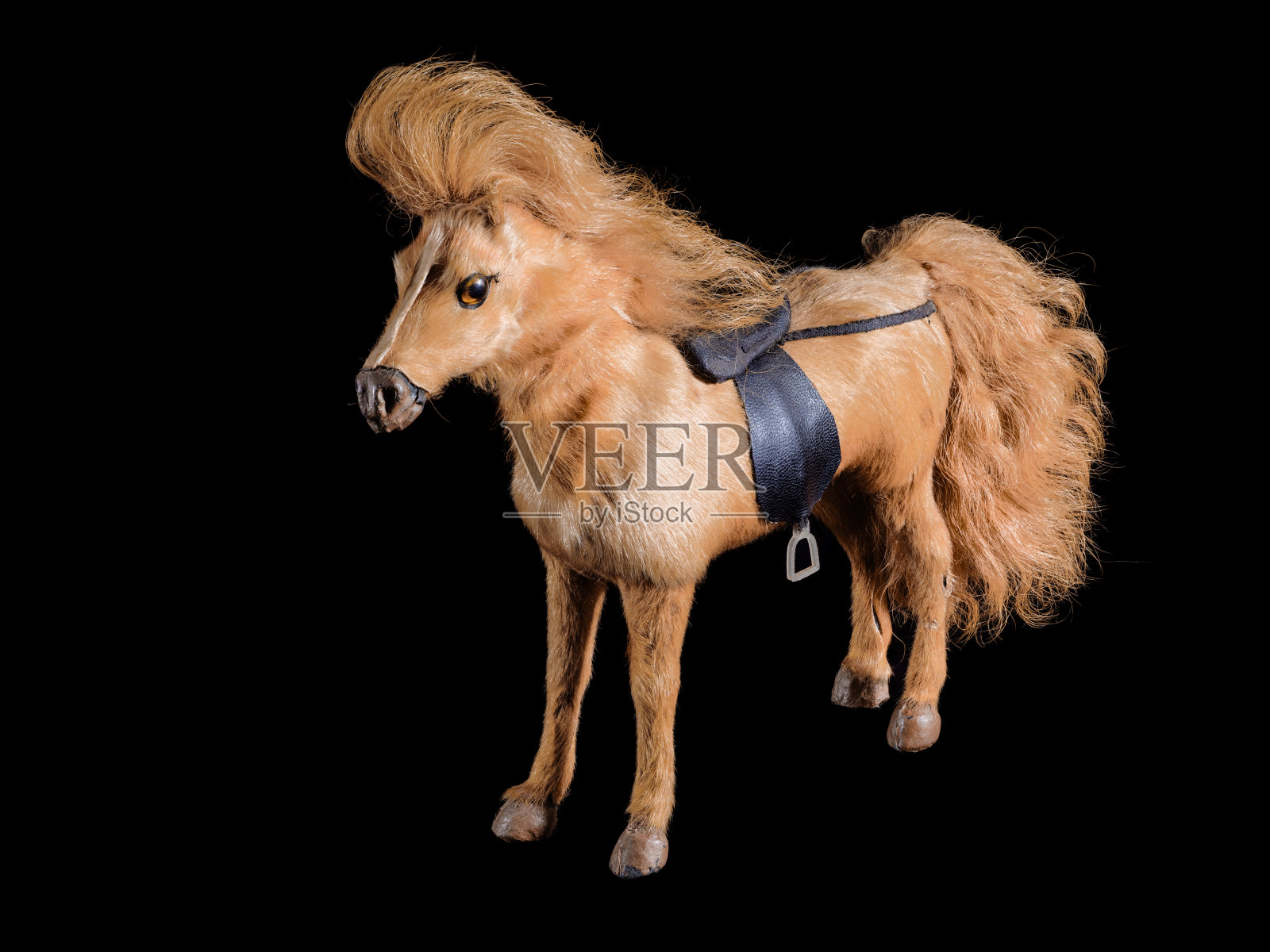 用于骑马的装饰玩具棕色马孤立在黑色上。照片摄影图片