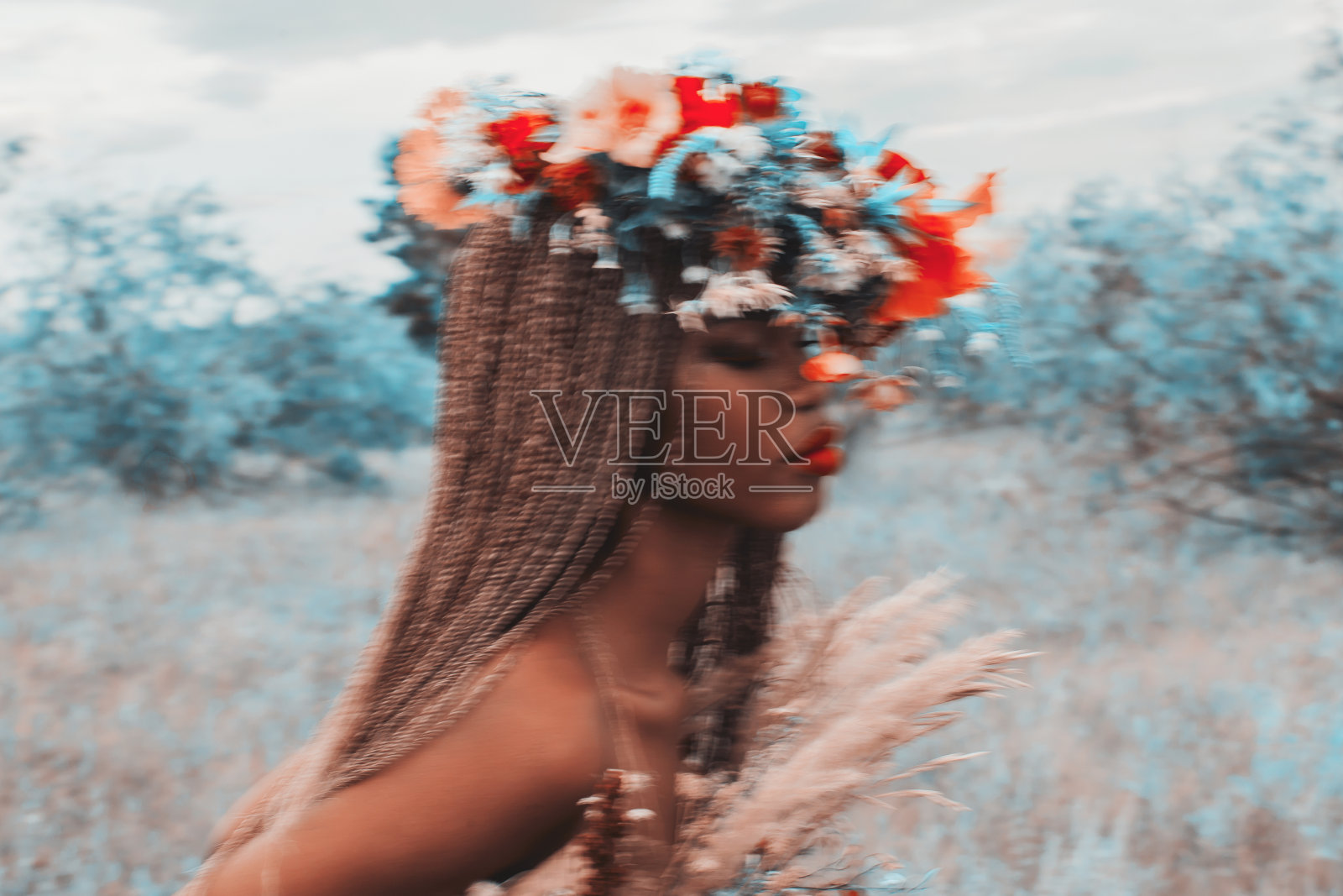 美丽的女人头戴花环，以自然为背景。真实的风格。时尚风格。夏天。留着非洲式发型的模特。草地照片摄影图片