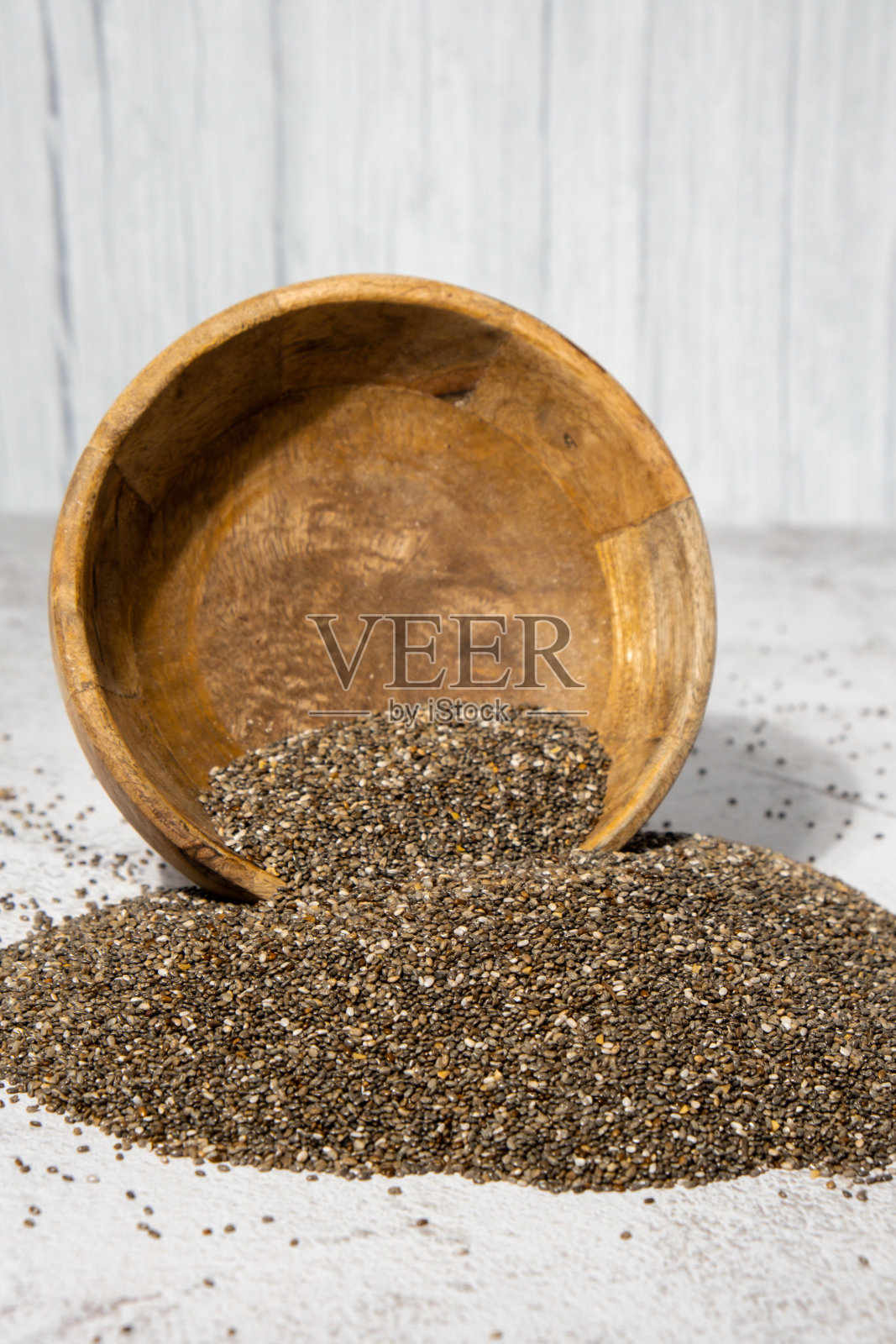奇亚籽从木碗里掉下来。富含Omega - 3脂肪酸的健康超级食物。干燥健康的天然成分。中国谷物价格下跌照片摄影图片