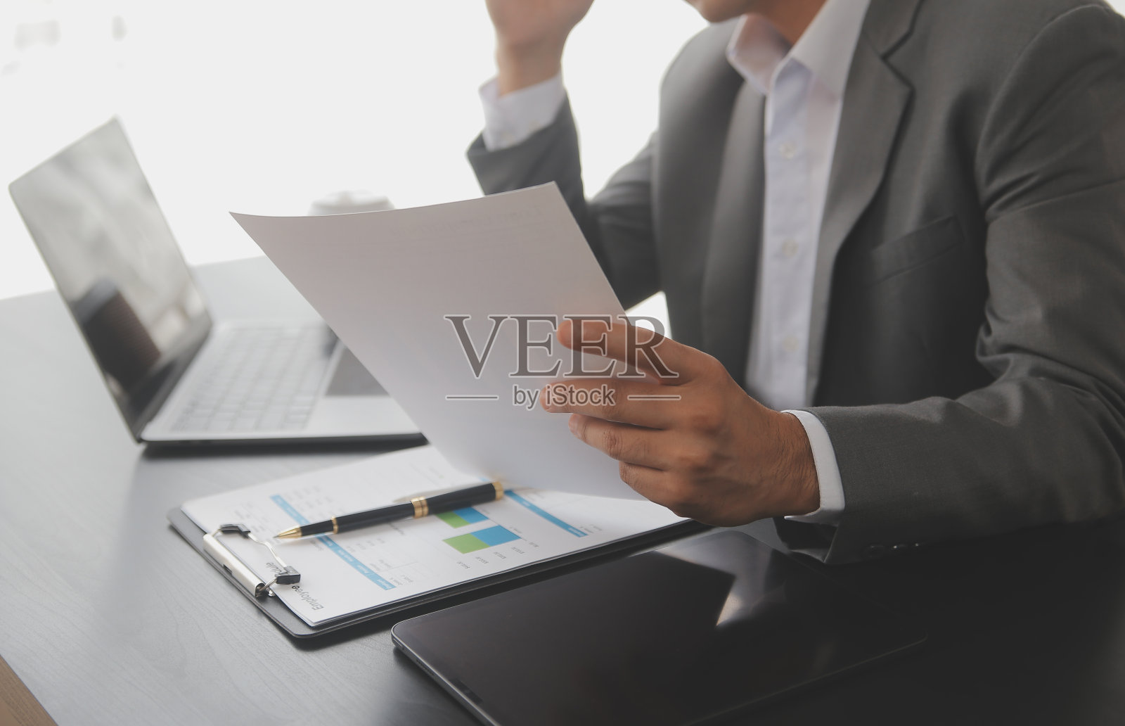 商人正在计算收入支出和分析房地产投资数据，会计财务和税收制度的概念。照片摄影图片