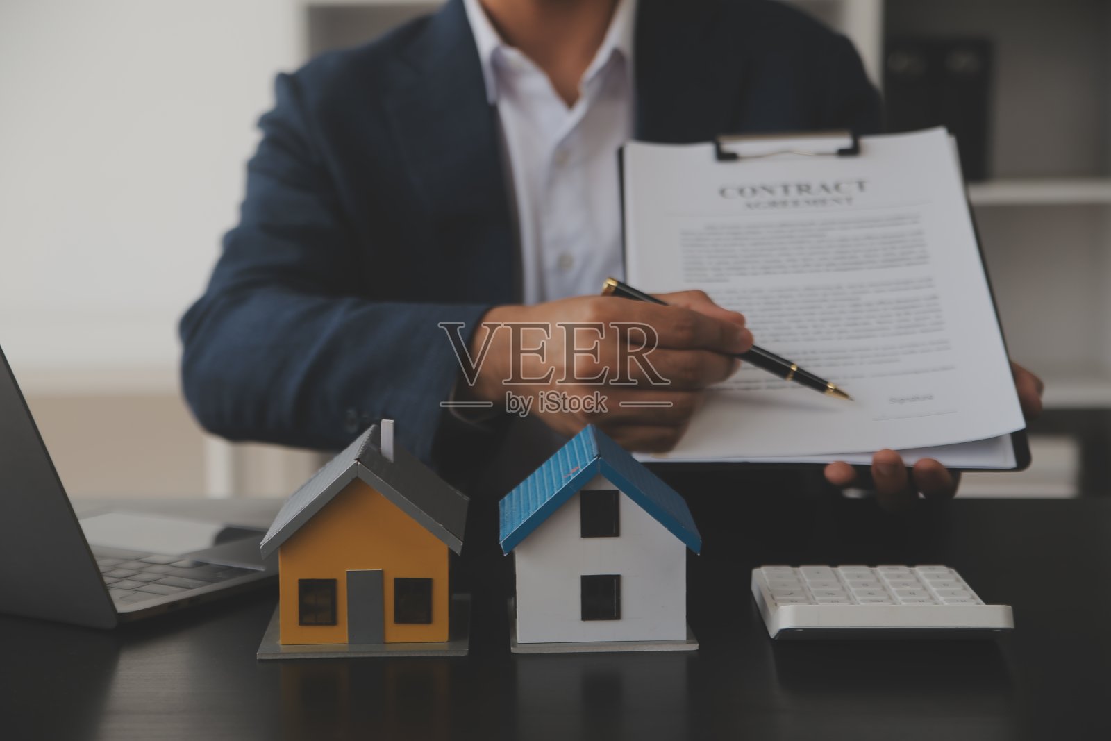 房地产经纪人向客户提出并咨询决策签订保险合同，买卖房屋模型，有关按揭贷款报价和房屋保险照片摄影图片