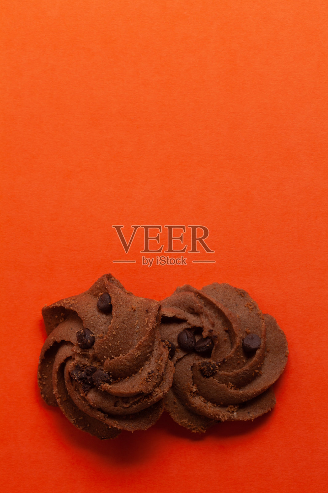 两块橙色背景的巧克力饼干。照片摄影图片