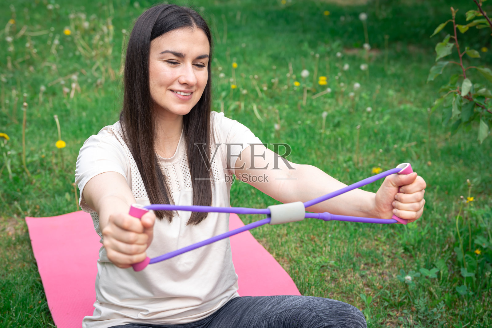 健身妇女在户外用健身橡皮筋锻炼。照片摄影图片