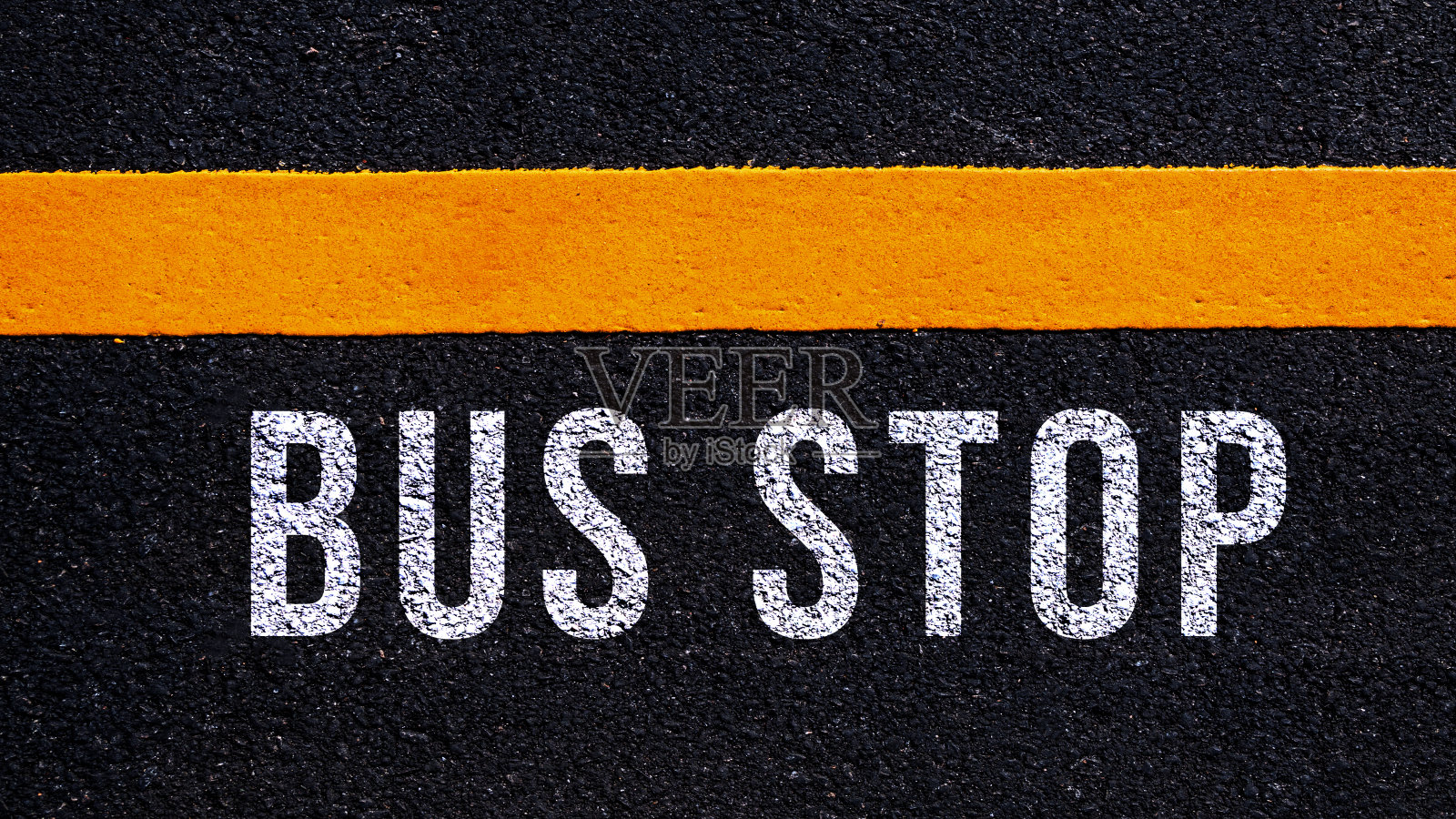 公交站牌文字和黄线写在柏油路中间，公交站牌文字写在街道上。照片摄影图片