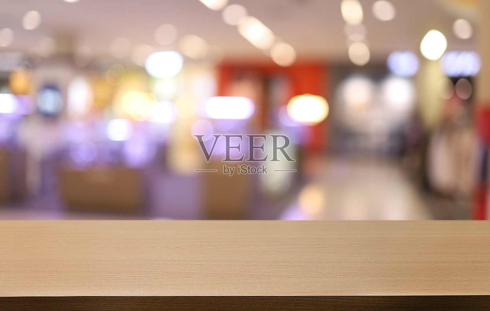 咖啡厅抽象模糊背景前的空木桌。可以用来展示或蒙太奇您的产品。产品展示的模型照片摄影图片