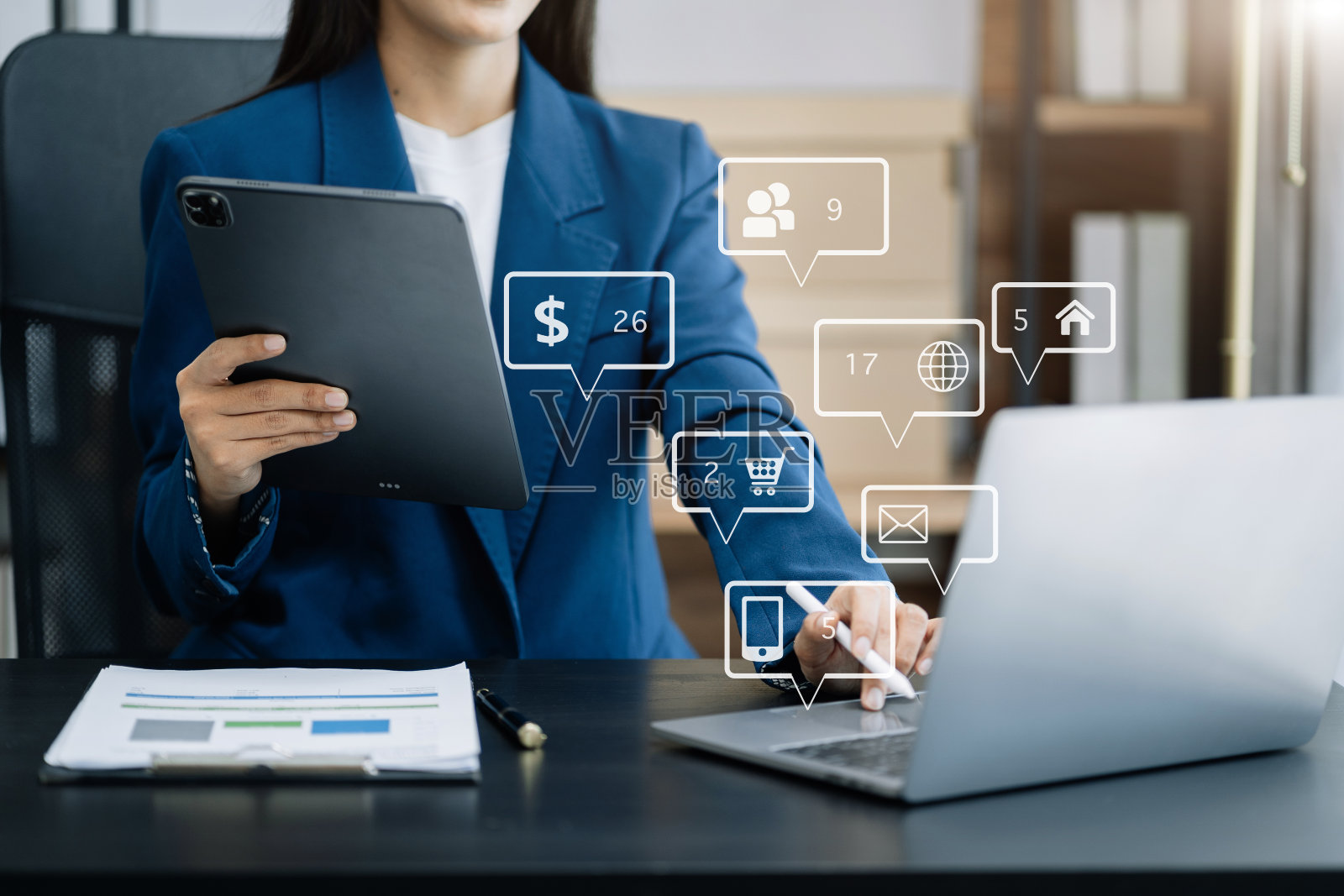 女性在现代办公室使用手机，笔记本电脑和数字平板电脑，在晨曦中在办公室使用VR图标图。照片摄影图片