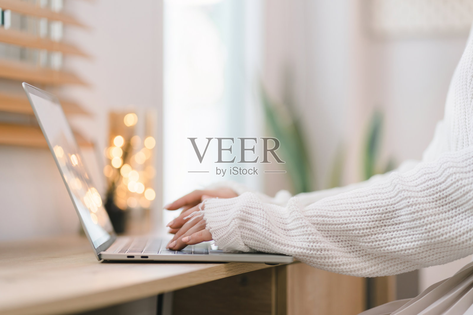 一位年轻的亚洲女性正用她的笔记本电脑在她舒适的家庭办公室里通过互联网进行交流。这描述了远程工作和电子学习的概念。照片摄影图片