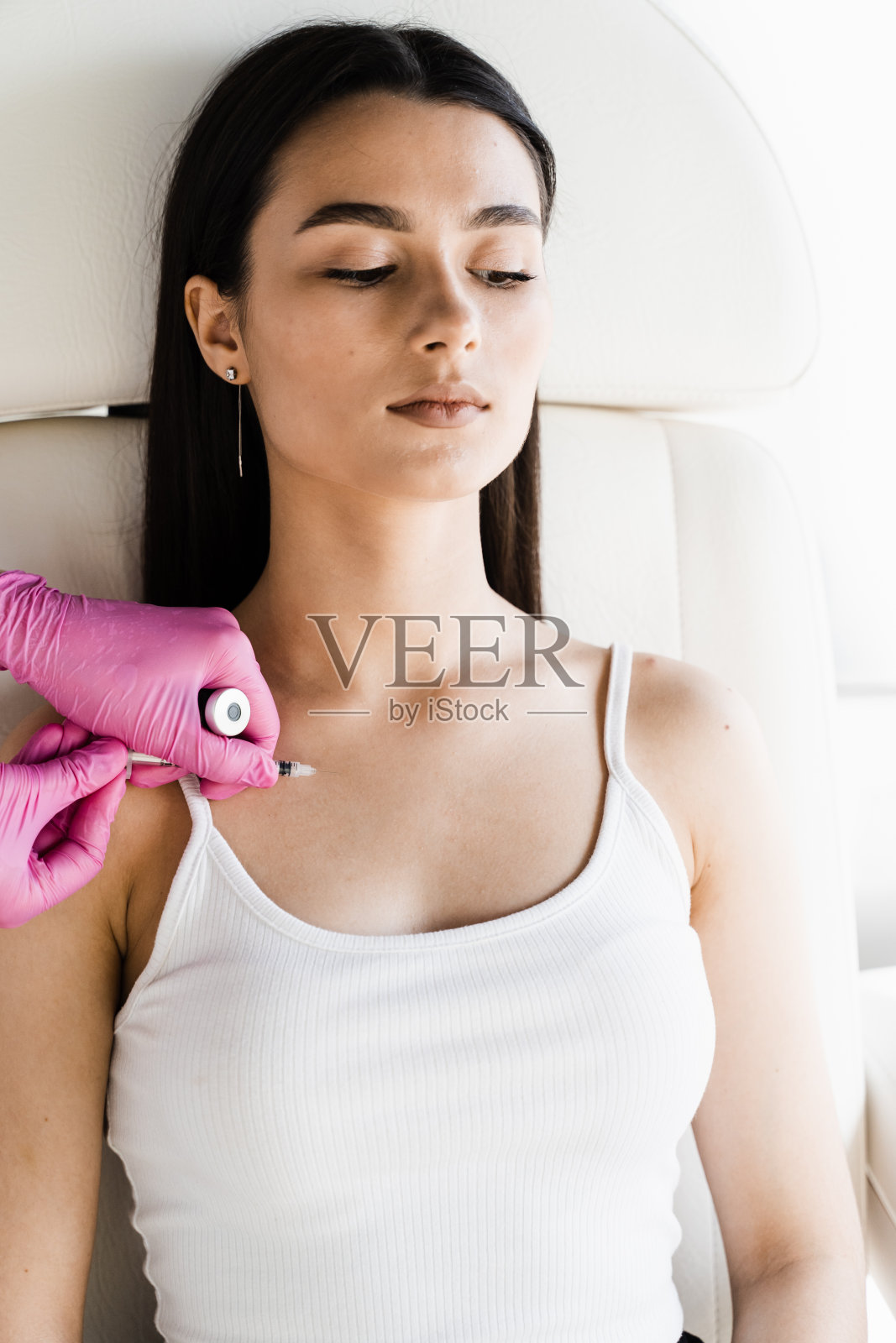 女孩领口注射美射疗法。注射维生素、酶、激素和植物提取物，使皮肤恢复活力和紧致，并去除多余的脂肪。照片摄影图片