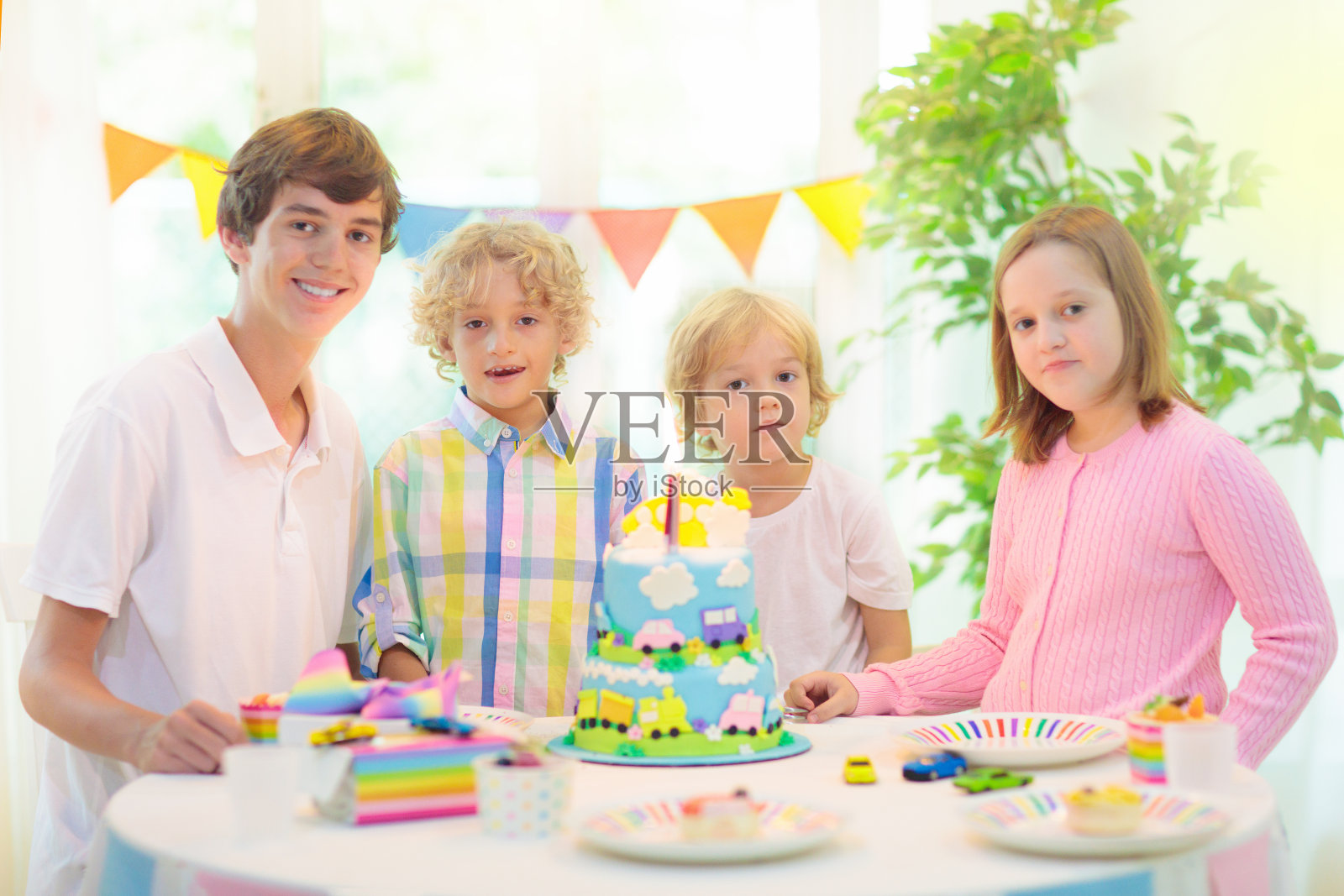 孩子们的生日聚会。孩子吹灭了蛋糕蜡烛照片摄影图片