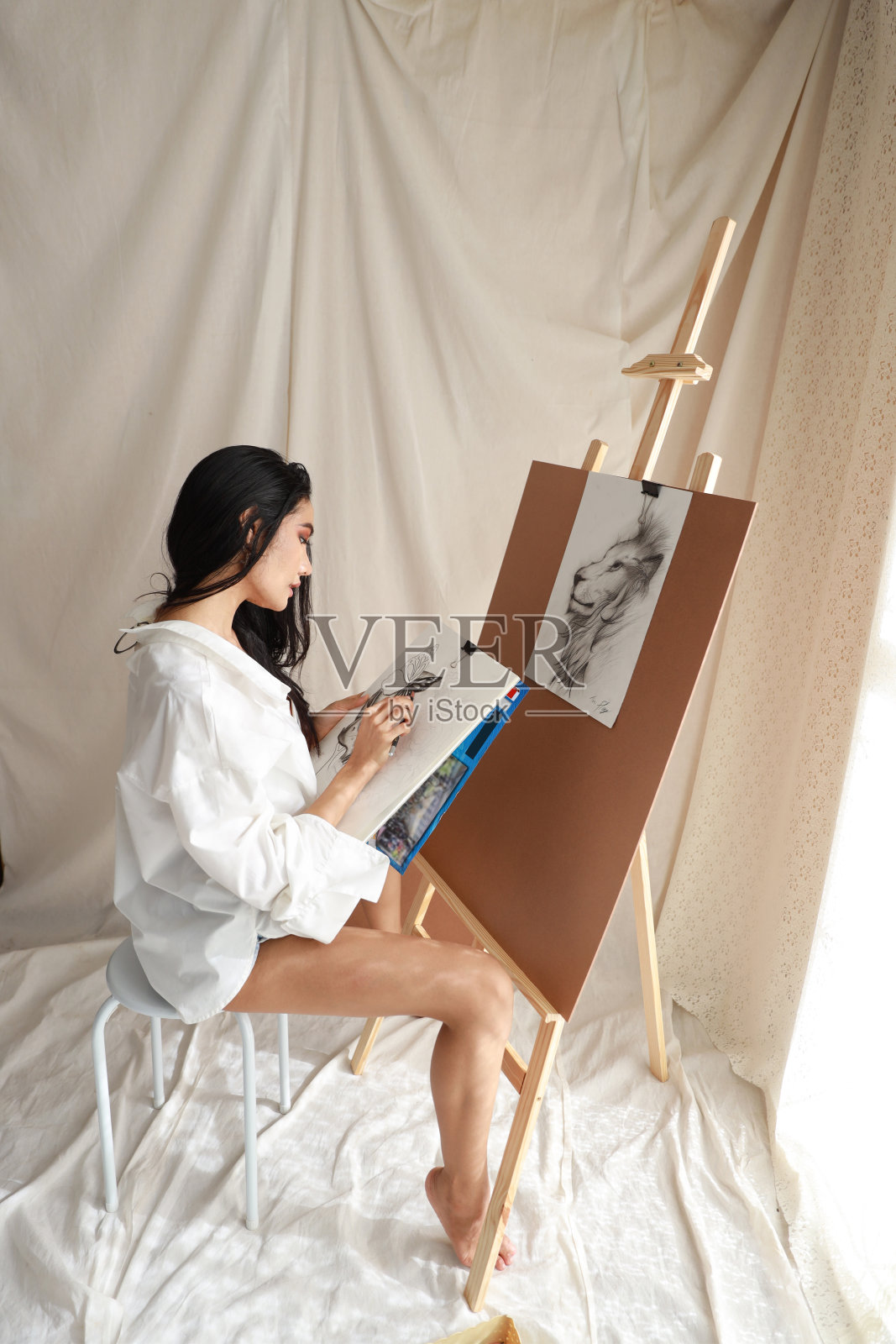 侧视图穿白衬衫的女艺术家用铅笔画画(女性生活方式概念)照片摄影图片