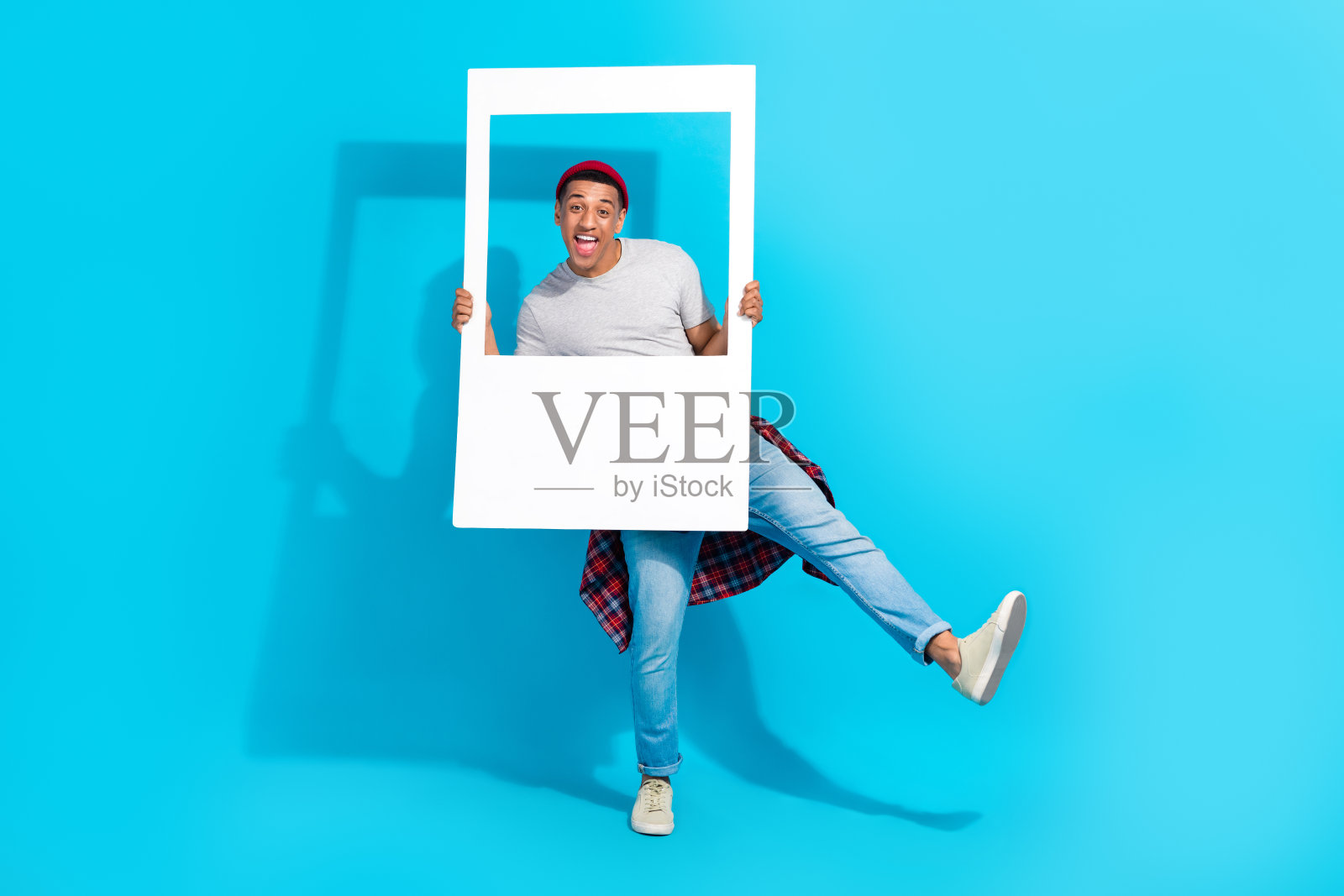 喜出望外的无忧无虑的人有好心情跳舞的全身肖像拿纸相册卡孤立在蓝色的背景照片摄影图片