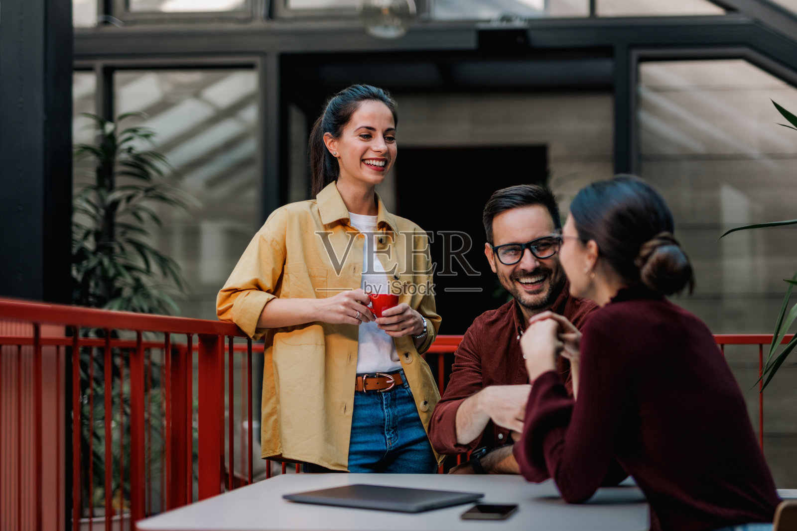 两个女人在工作间隙和一个商人谈话。照片摄影图片
