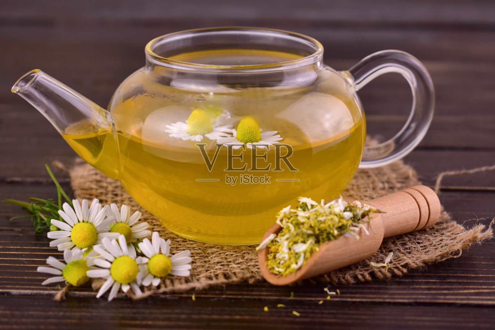 洋甘菊茶在一个玻璃茶壶在黑暗的背景。治疗茶。照片摄影图片