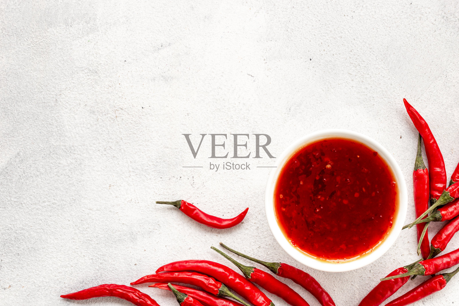 红熟辣椒和辣酱倒入碗中照片摄影图片