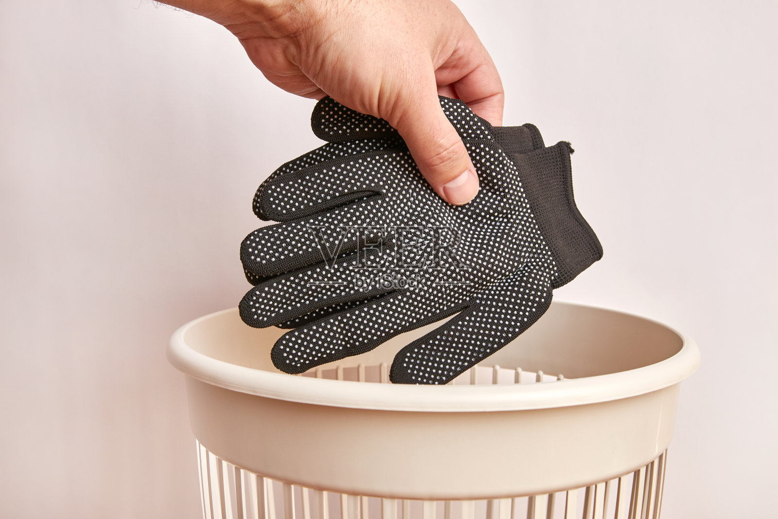 手套被扔进垃圾桶。处理和回收衣物。照片摄影图片