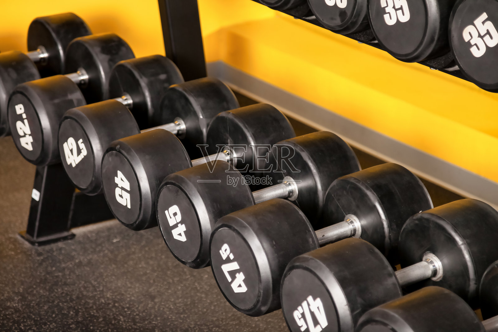 现代健身房内部与运动器材-运动哑铃架。新的健身中心库存的体育赛事和训练练习。概念运动设计背景。复制文字空间，海报照片摄影图片