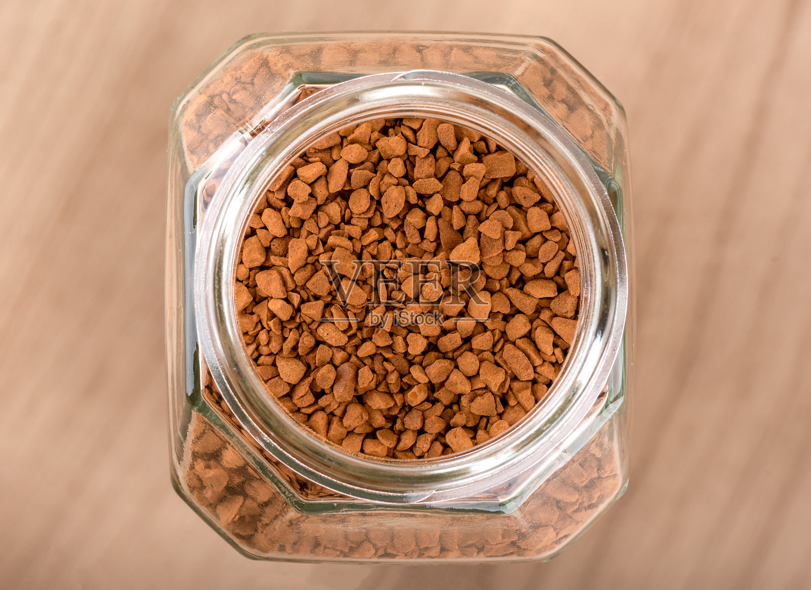 木质背景上一个装有速溶咖啡颗粒的开放式玻璃罐的俯视图。照片摄影图片