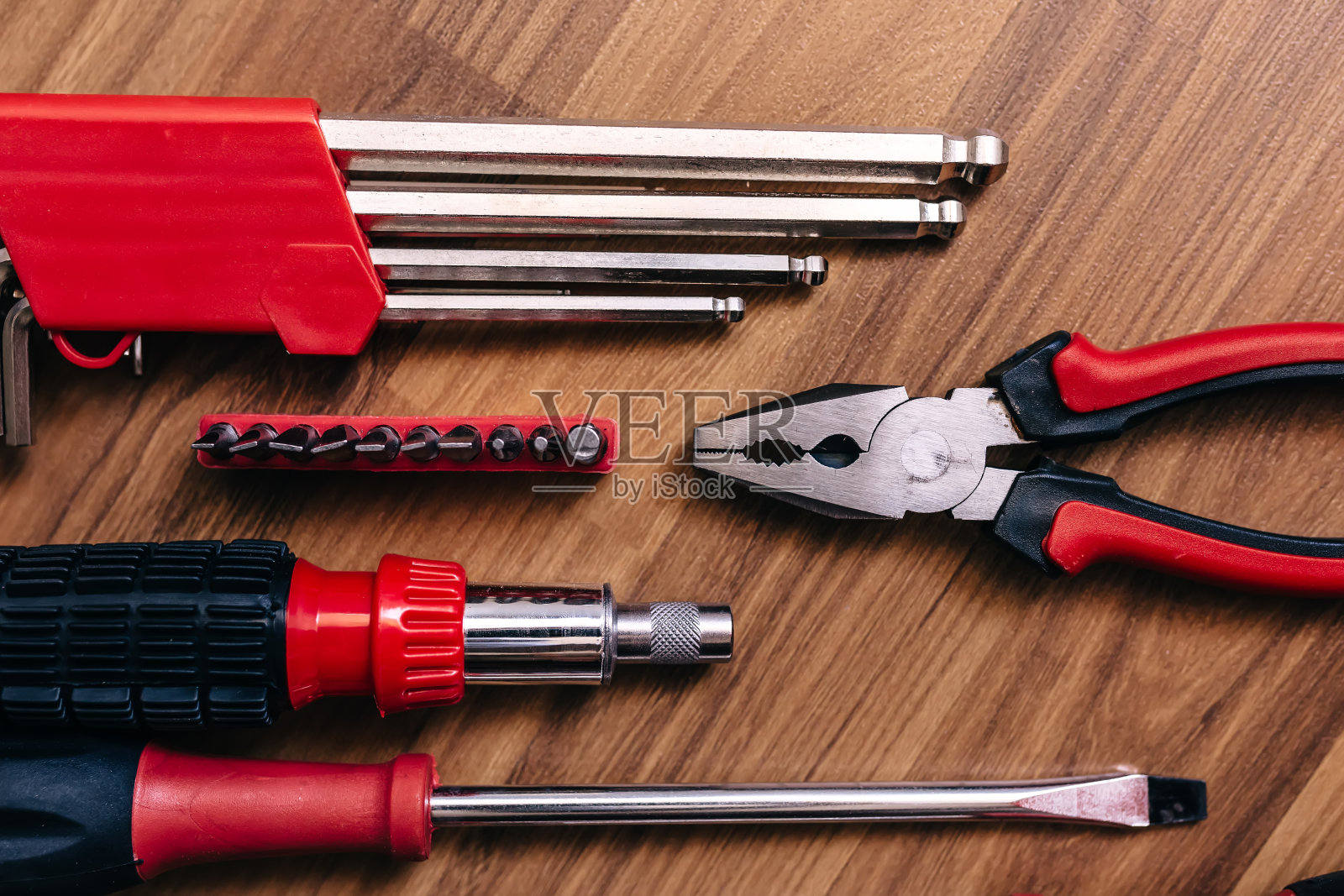 木制地板上的六角钥匙、螺丝刀和钳子的俯视图照片摄影图片