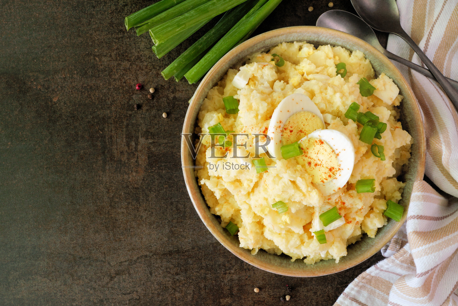 传统的土豆沙拉，上下颠倒的桌景在暗石上照片摄影图片