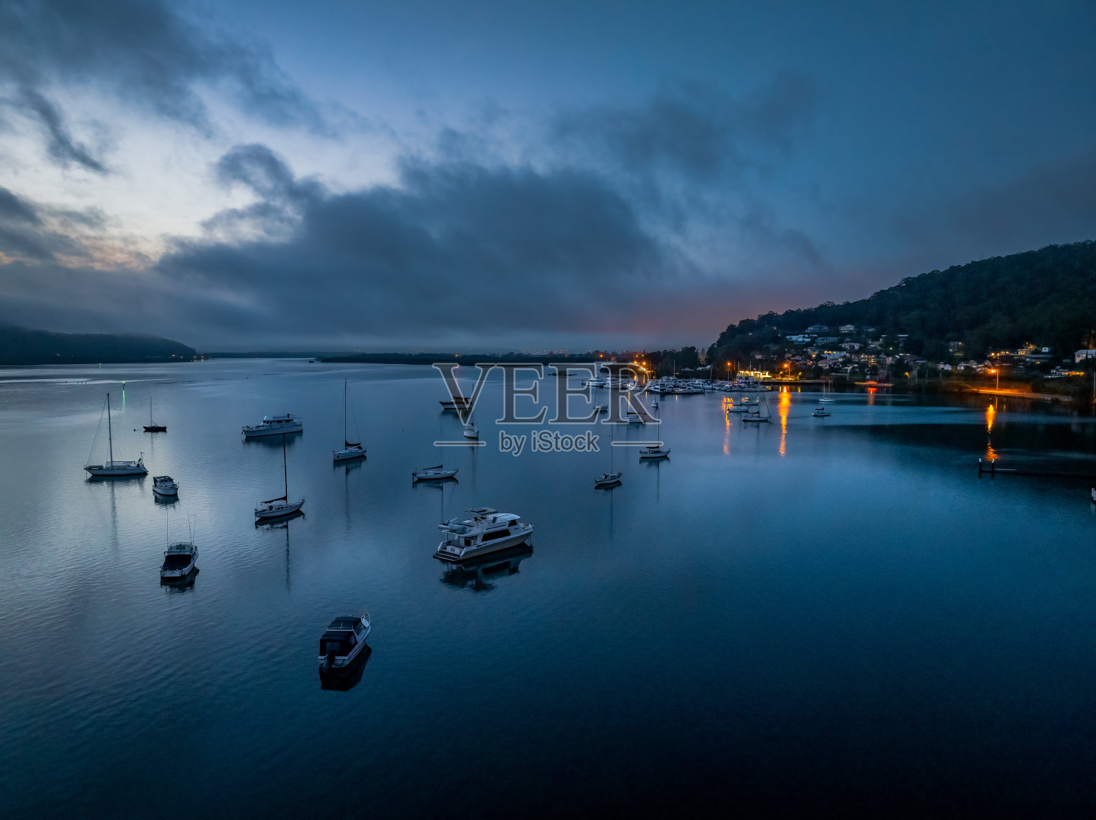 雾蒙蒙的日出和小船在水面上照片摄影图片