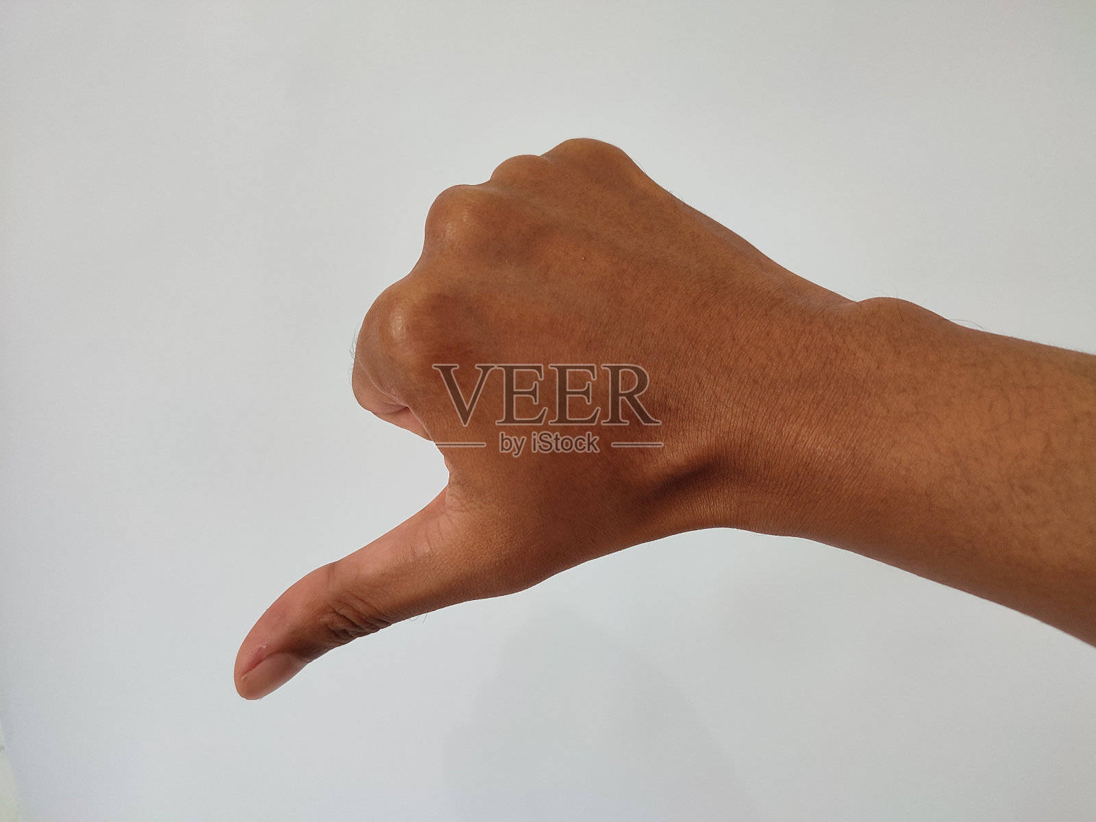 左手拇指向下孤立在白色背景的左侧。拒绝的象征照片摄影图片