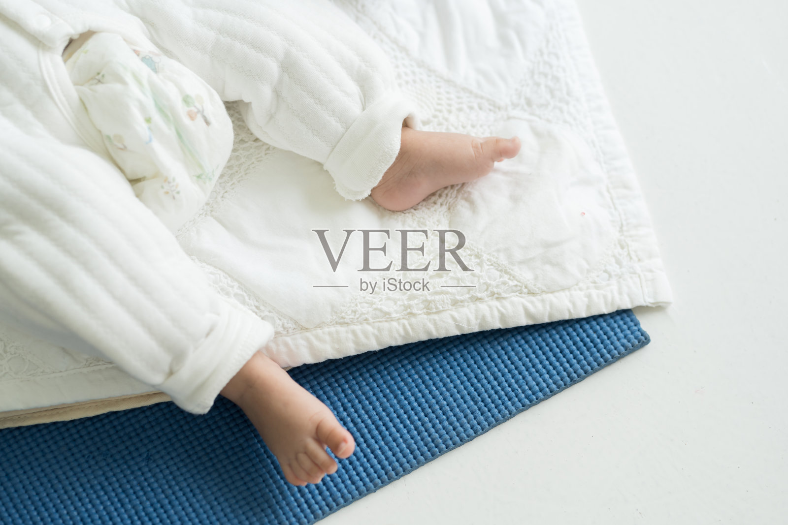 新生儿在毯子上睡觉时的小脚俯视图。刚出生的婴儿脚。亚洲新生婴儿足照片摄影图片