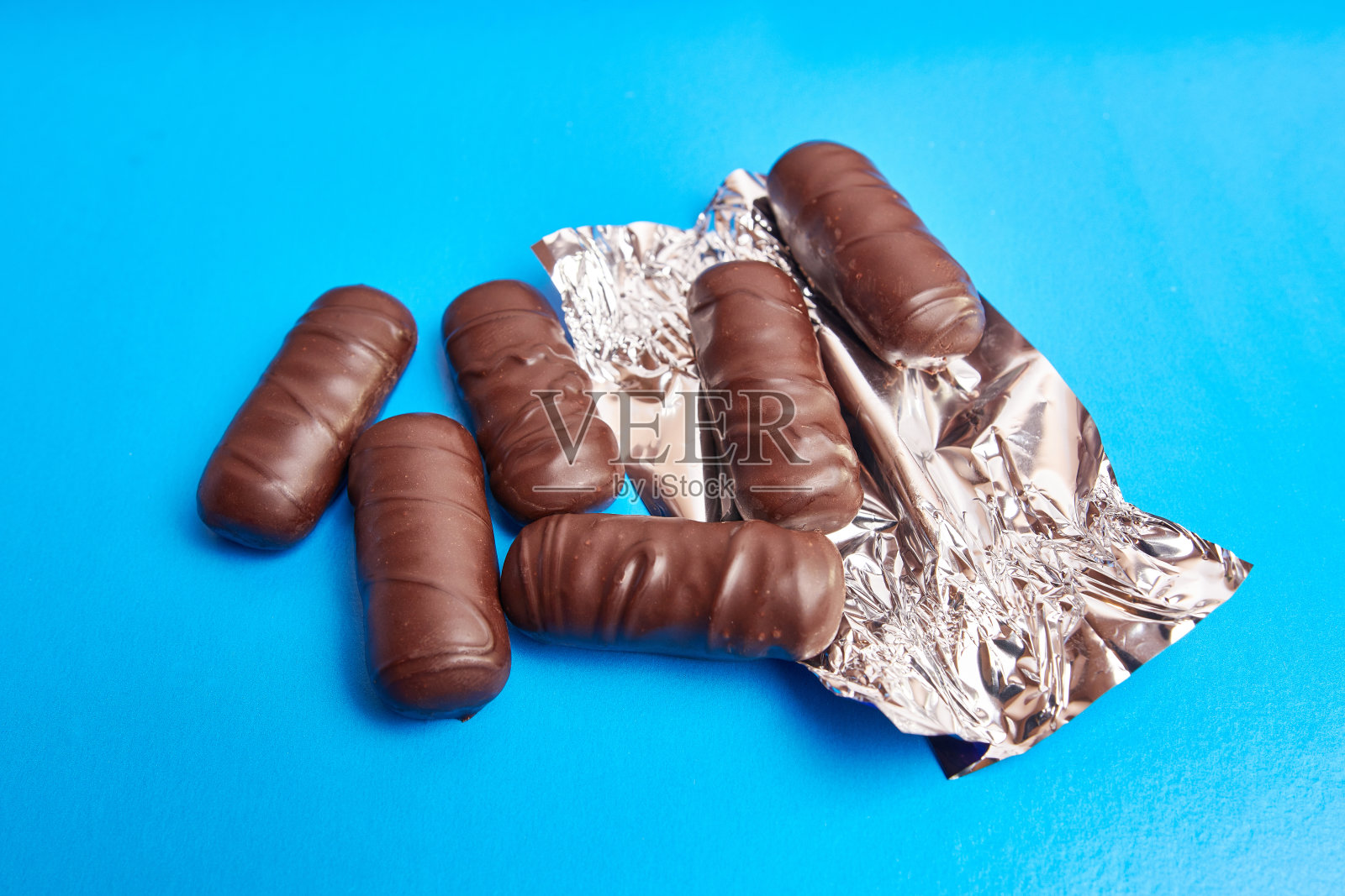 蓝色背景包装的巧克力糖果。照片摄影图片