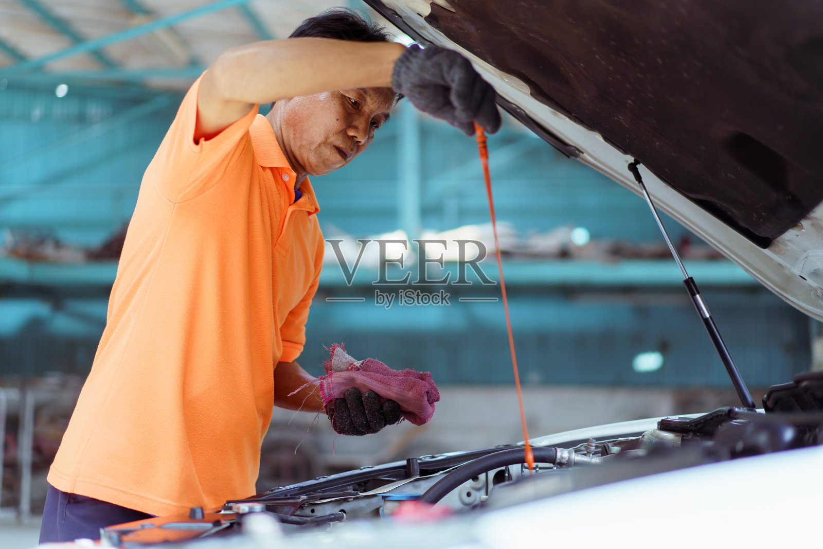 车辆技师检查发动机机油。照片摄影图片