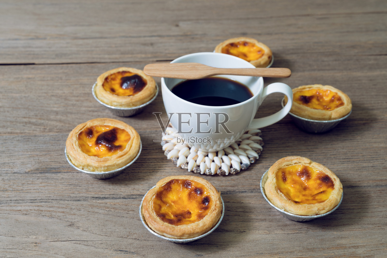 咖啡和蛋挞用铝箔杯放在木桌上照片摄影图片
