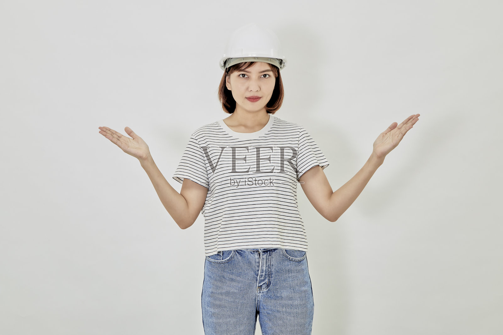 微笑的亚洲女商人戴着安全帽，穿着西装，双臂交叉，出售新建筑照片摄影图片