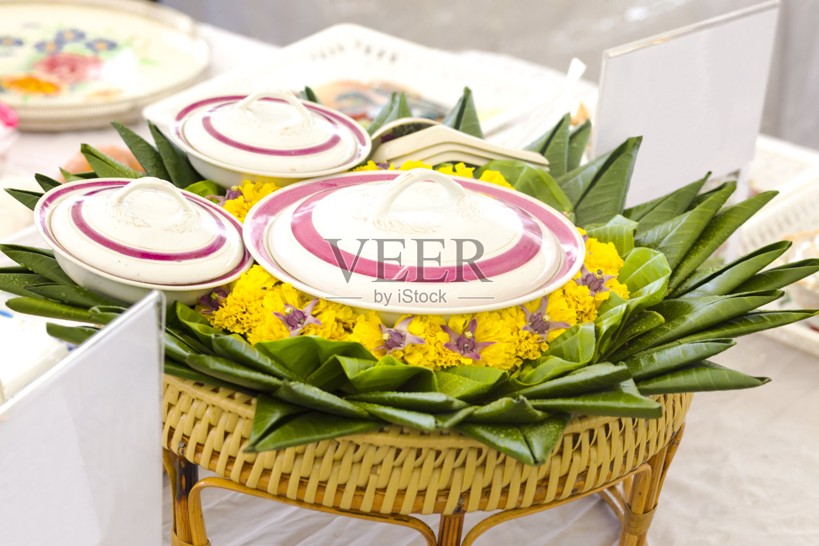 有花和香蕉叶装饰的篮子和泰国食物的盘子照片摄影图片