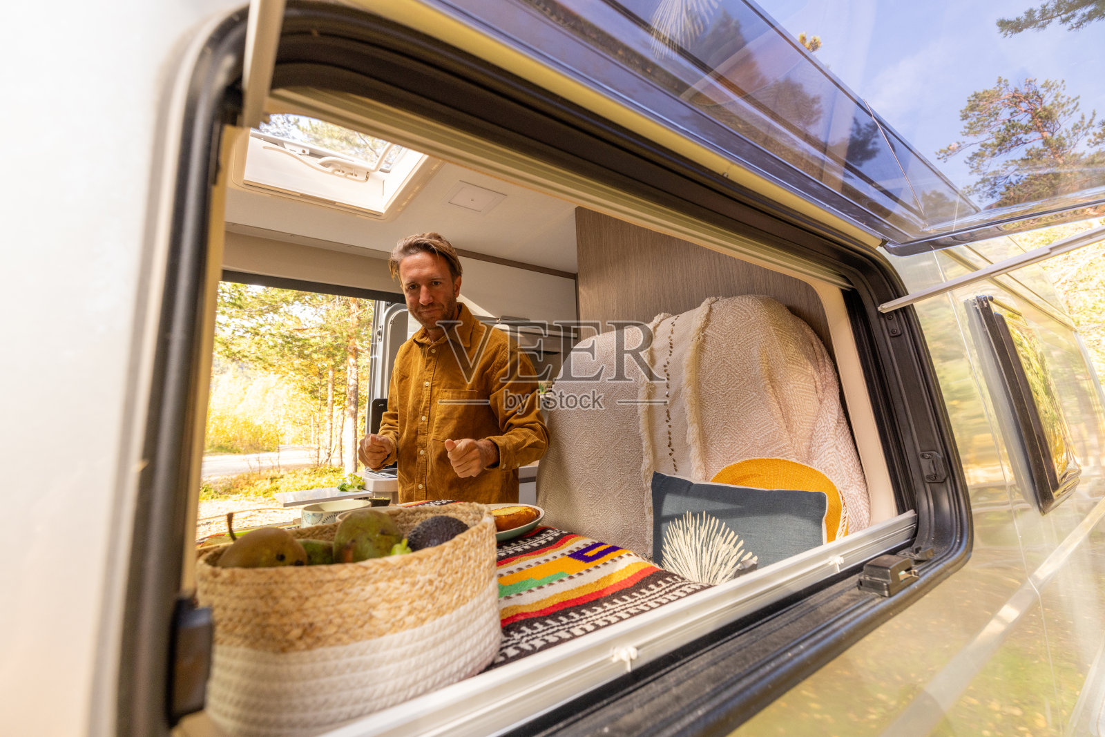 一名男子在他的露营车里准备食物。露营的概念照片摄影图片