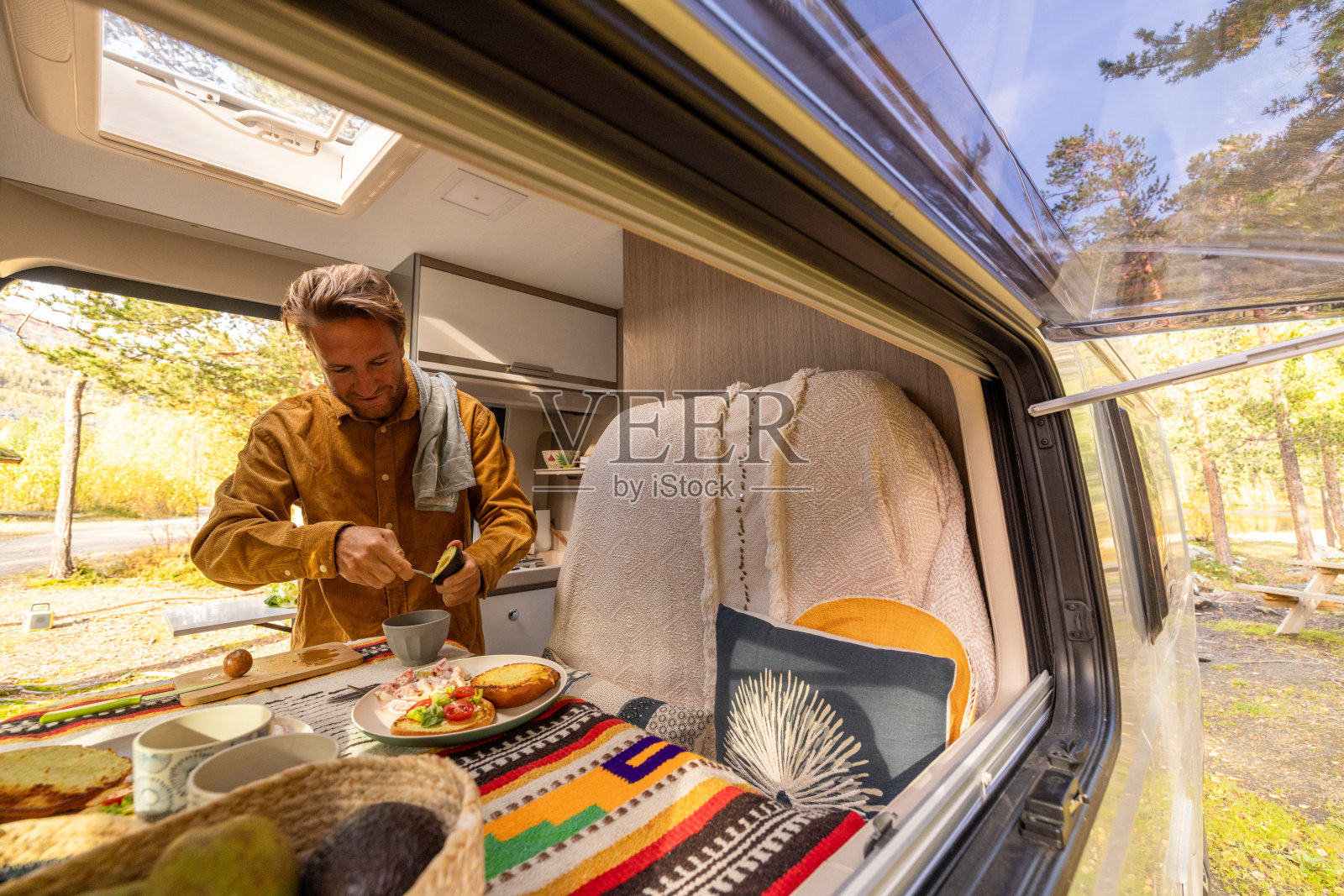 一名男子在他的露营车里准备食物。露营的概念照片摄影图片