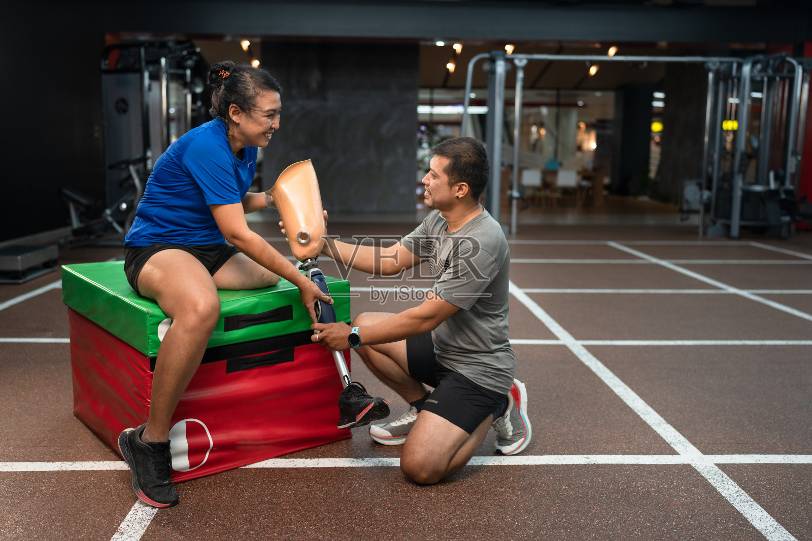 装有义肢的妇女和丈夫在健身或健身房照顾照片摄影图片