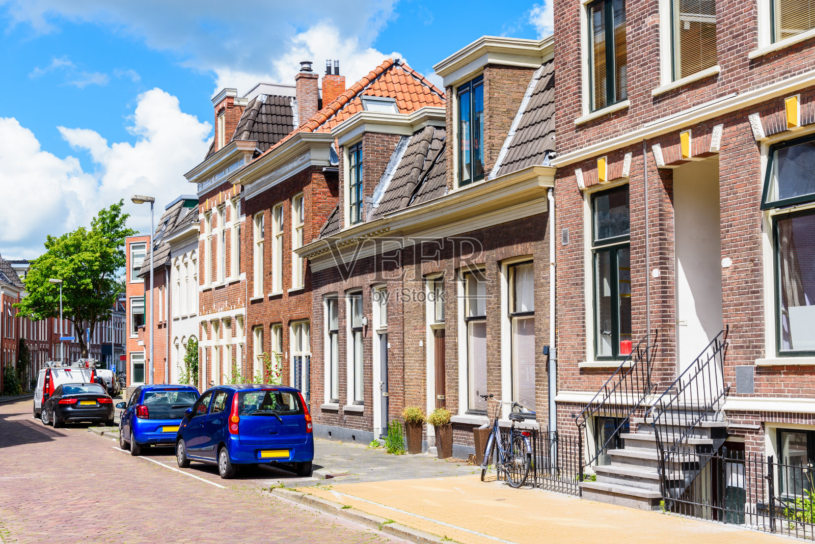 在一个阳光明媚的夏日，鹅卵石街道两旁的砖房照片摄影图片