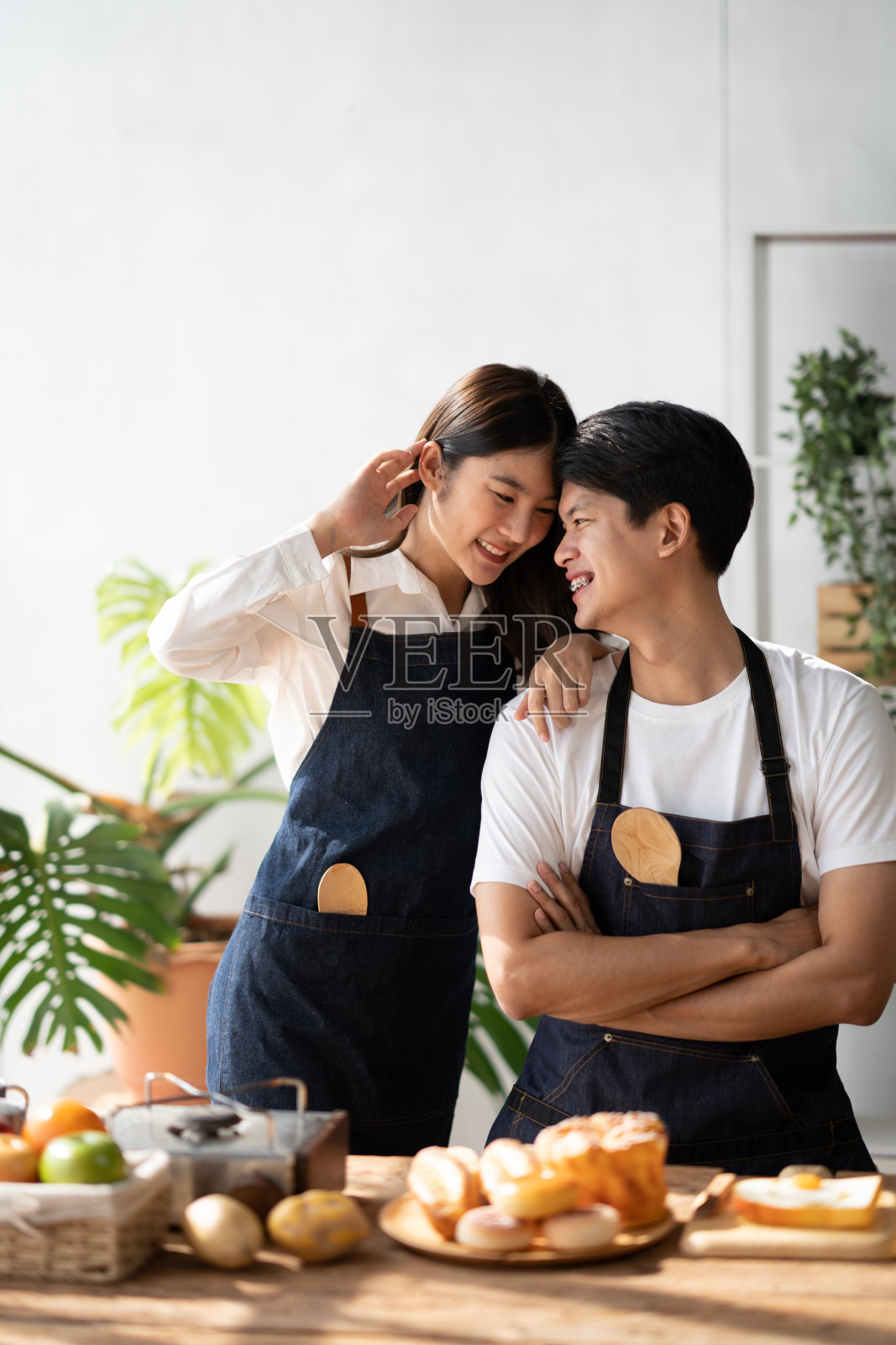 幸福的成熟夫妇在厨房里共度美好时光，为浪漫的晚餐准备食物，共度时光。照片摄影图片