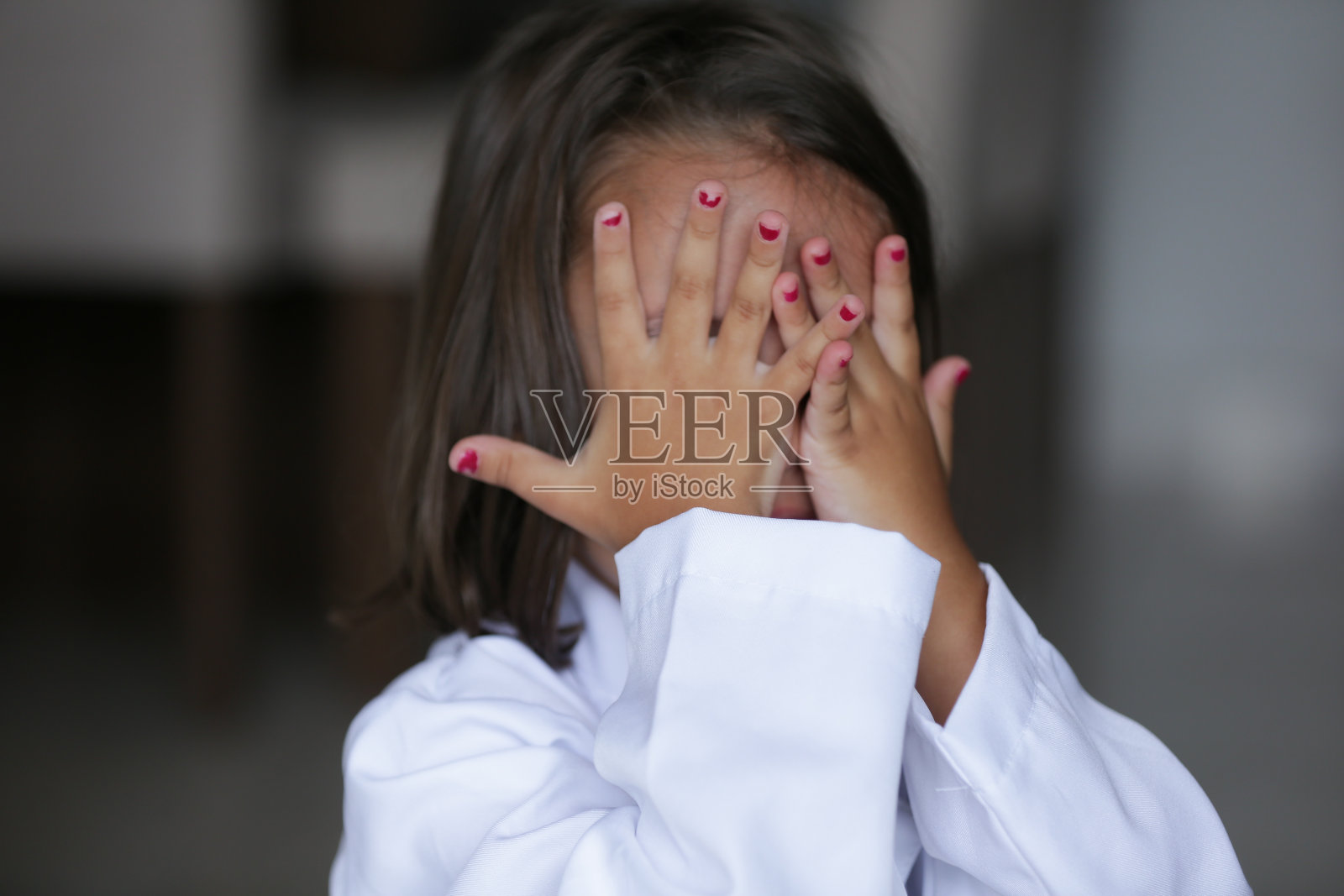 孩子用手捂脸，用另一只手示意停止。照片摄影图片