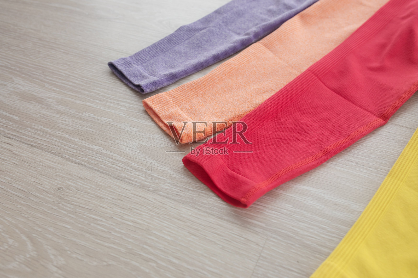 灰色背景上的彩色运动打底裤。照片摄影图片