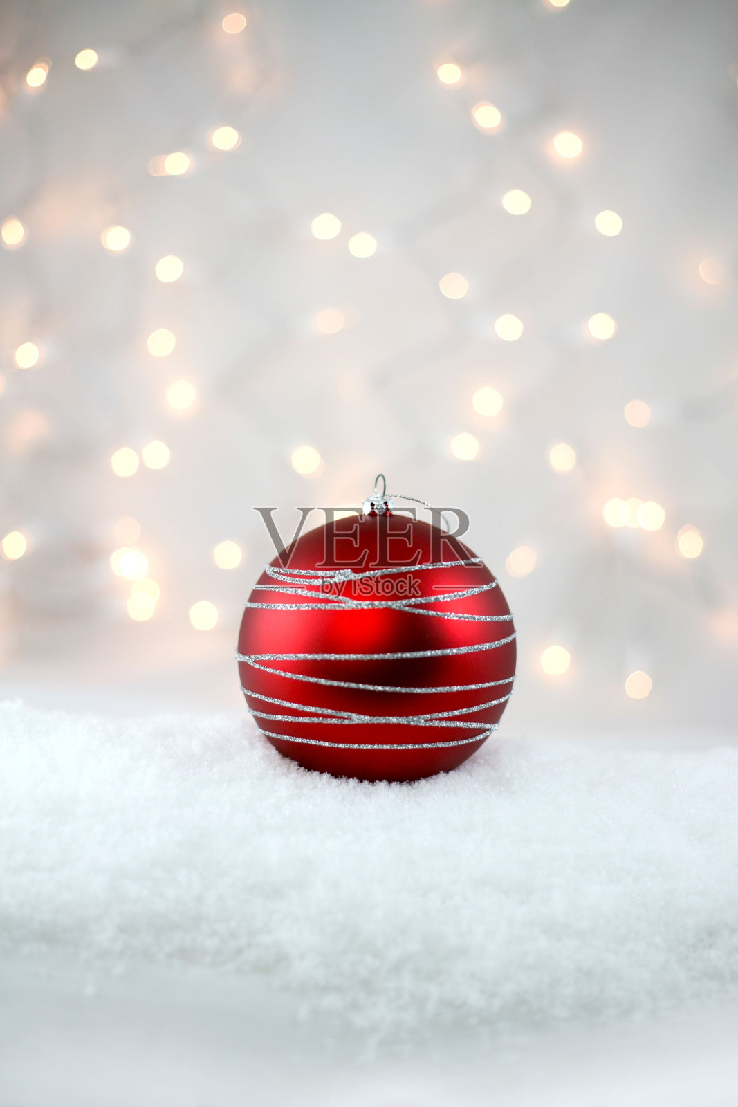 红色装饰假日灯泡与银色闪闪发光坐在柔软蓬松的雪。照片摄影图片