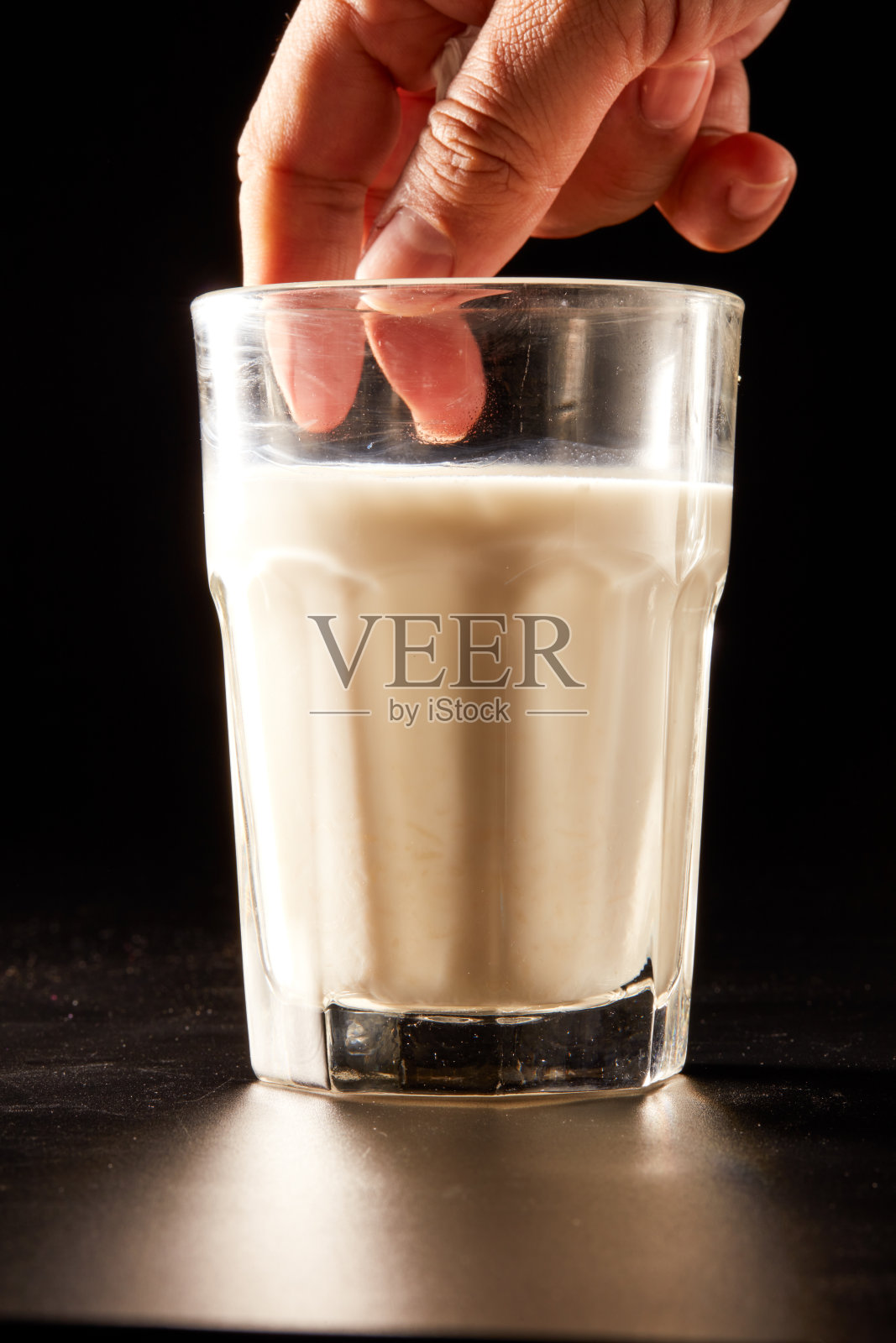 一杯豆浆在黑色背景上的特写照片摄影图片