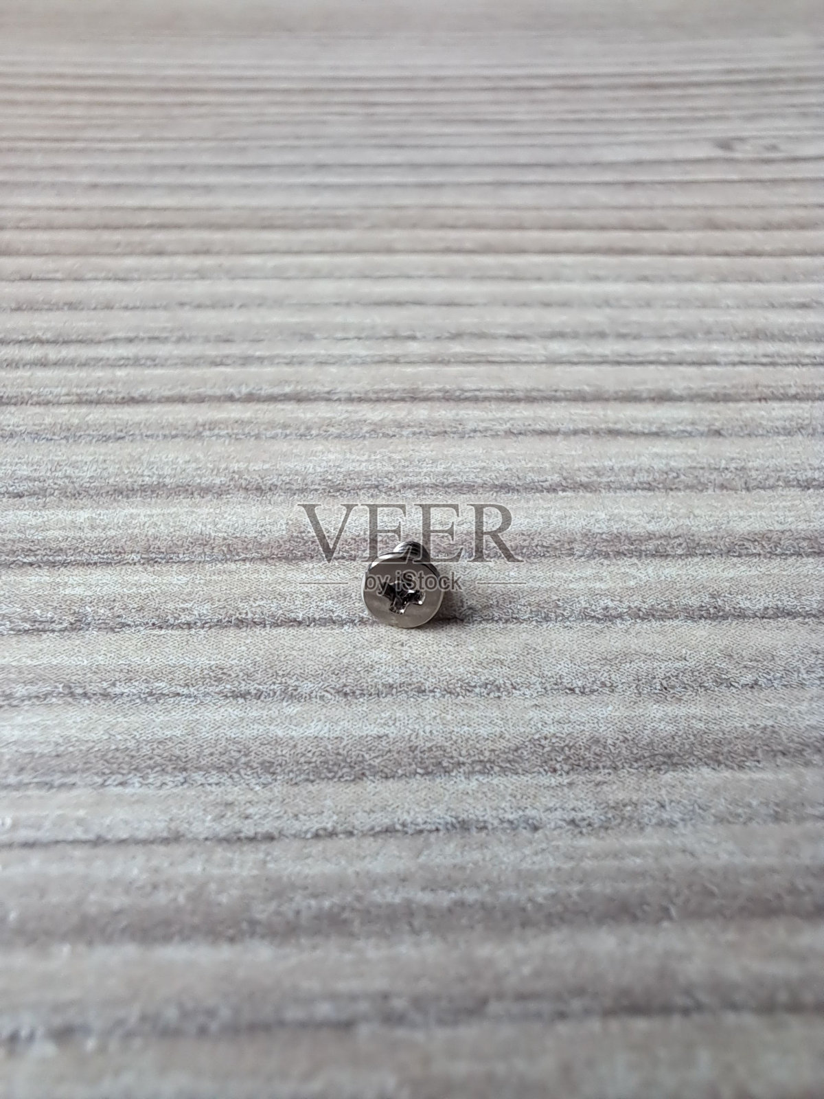 平织物表面上银螺丝钉的垂直特写照片摄影图片