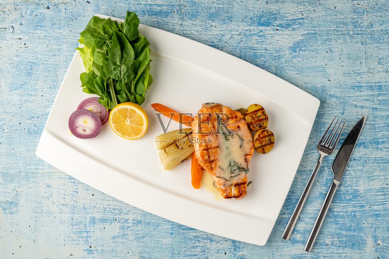 白瓷盘上的酱汁烤三文鱼配蔬菜和土豆照片摄影图片