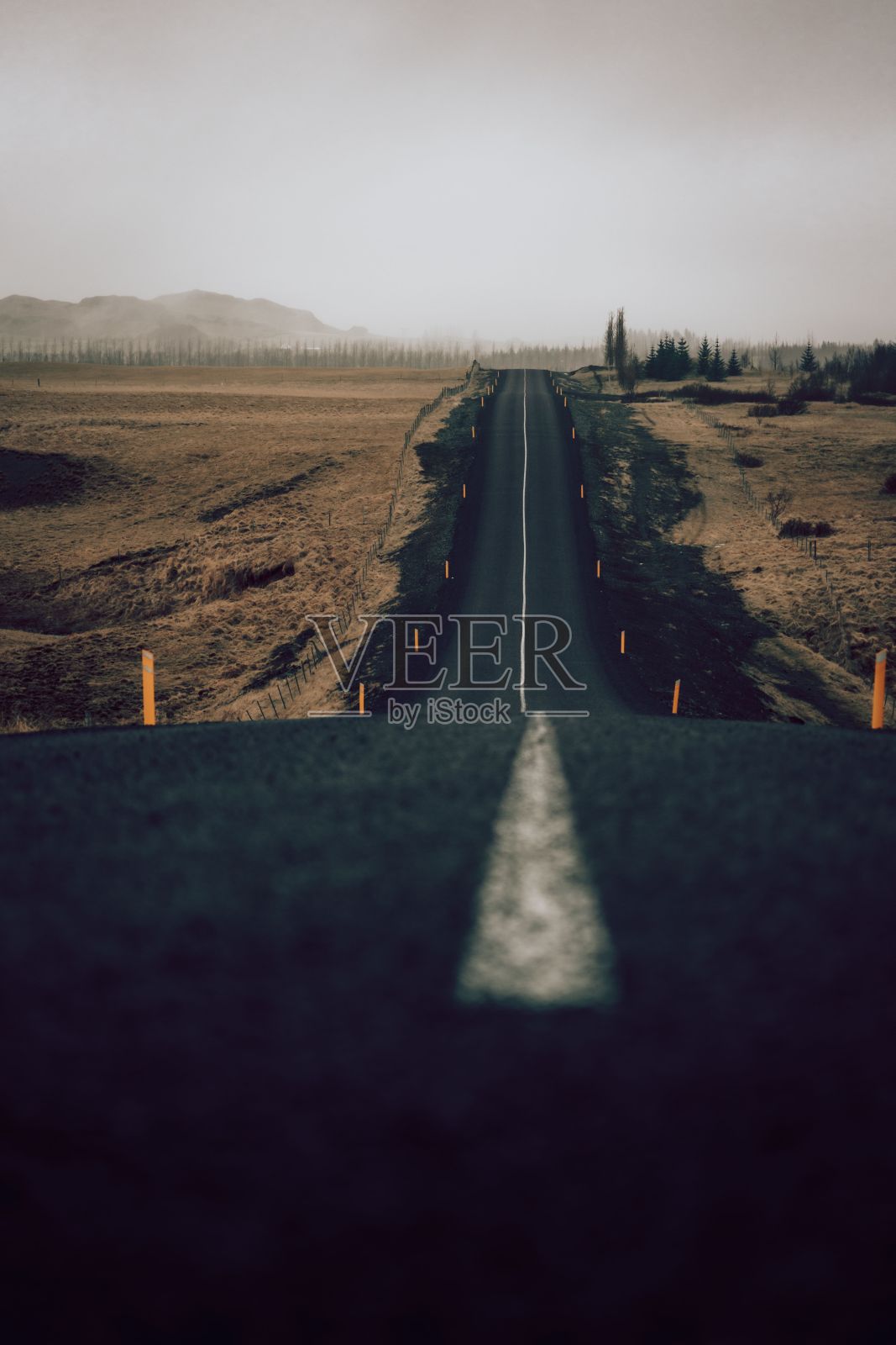 阴天的乡间，风景如画的空旷乡间小路，周围是郁郁葱葱的草地照片摄影图片