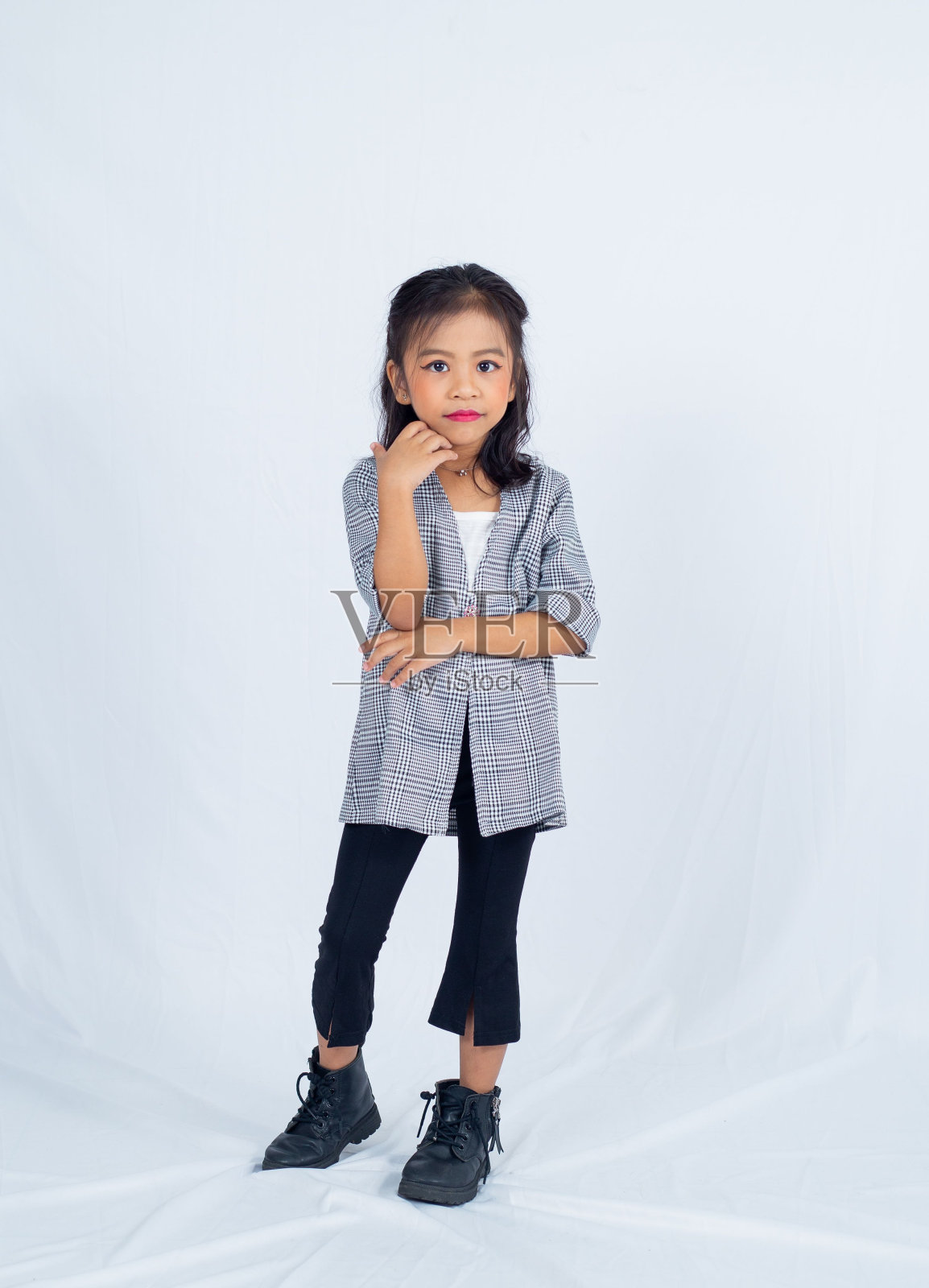 一个年轻的女孩穿着灰色衬衫和黑色牛仔裤在镜头前摆姿势照片摄影图片