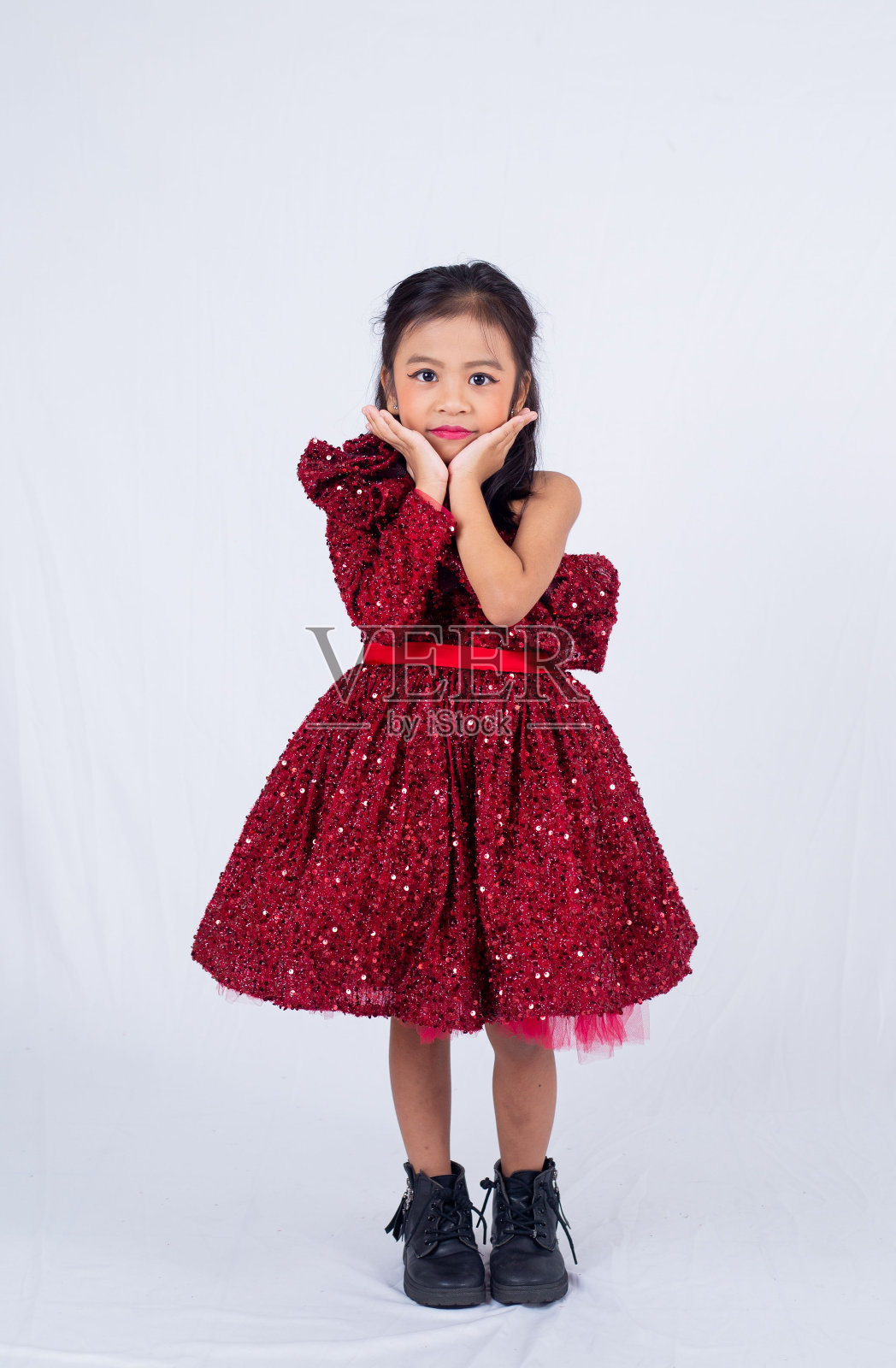 一个小女孩穿着带亮片的红色连衣裙照片摄影图片